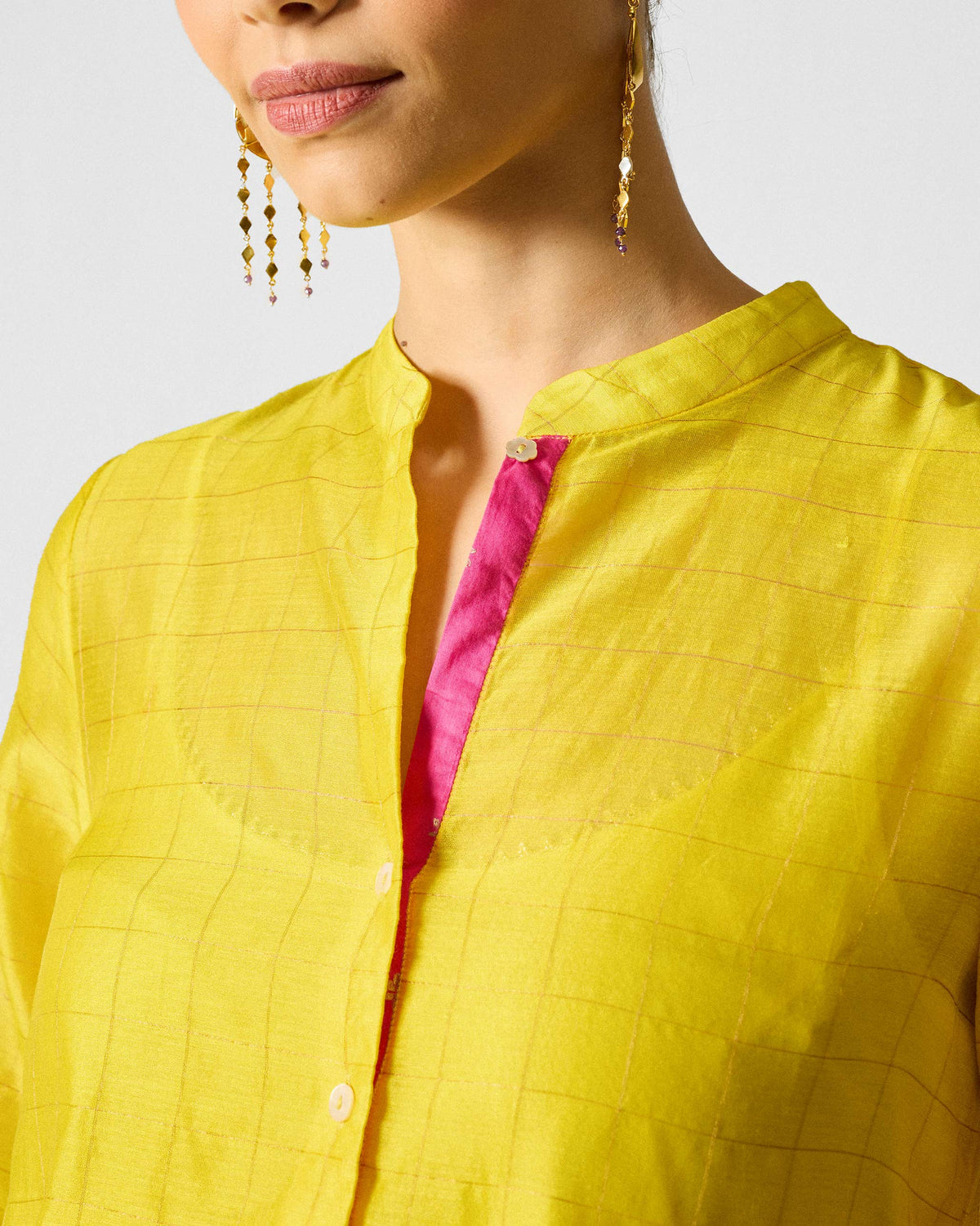 Close-up of a lime and gold checked Kumaon Kurta showing a pink-lined placket.