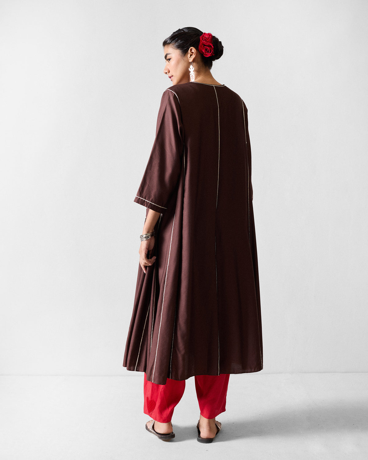 Back of a chocolate brown Aheli kurta with white piping down the center.