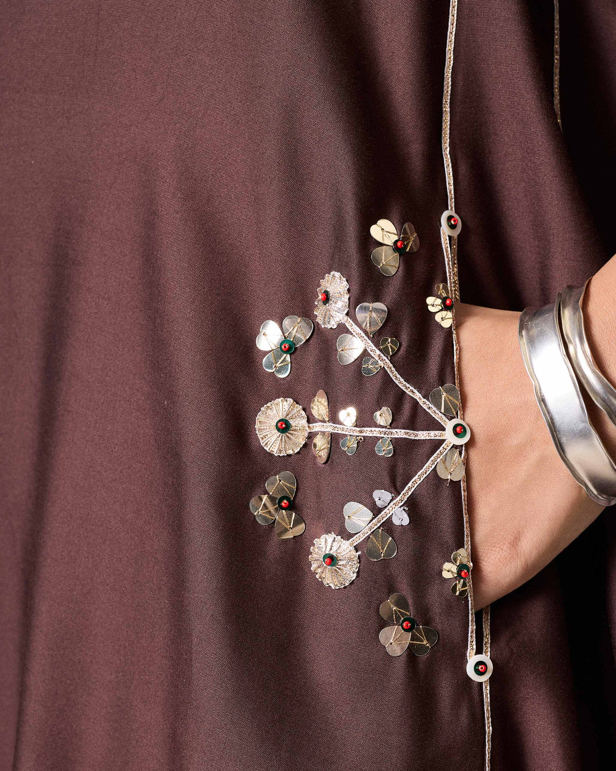 Close-up of a chocolate brown Aheli kurta showing gold floral embroidery at the pocket.