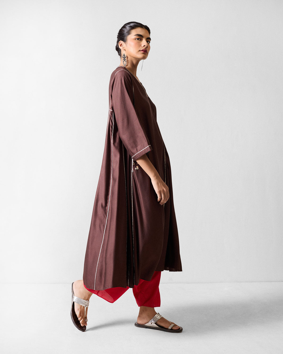 Person wearing a chocolate brown Aheli kurta with side floral embroidery.