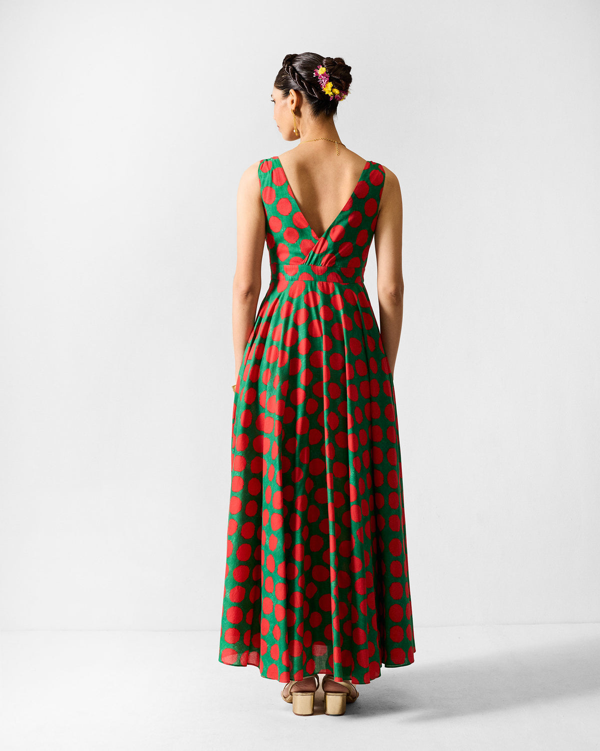 Back of a green Tribe dress with a deep V and red polka dots.