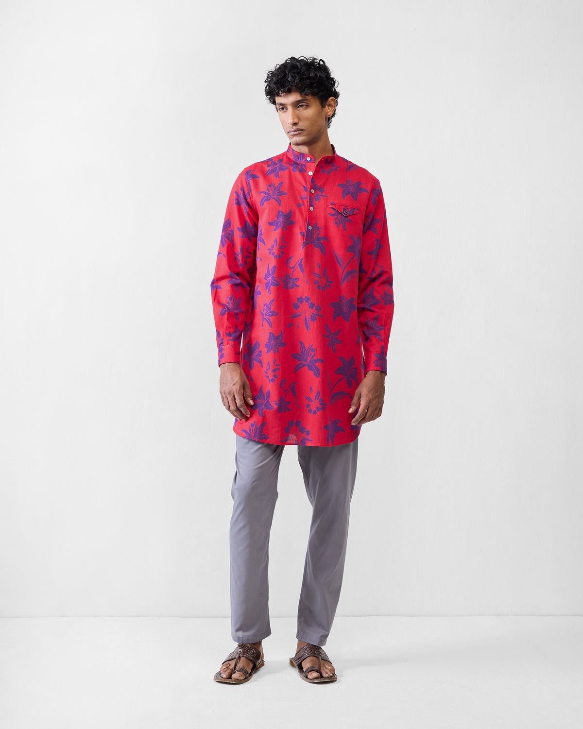 Person wearing a red Fort kurta with purple lily print and a chest pocket.