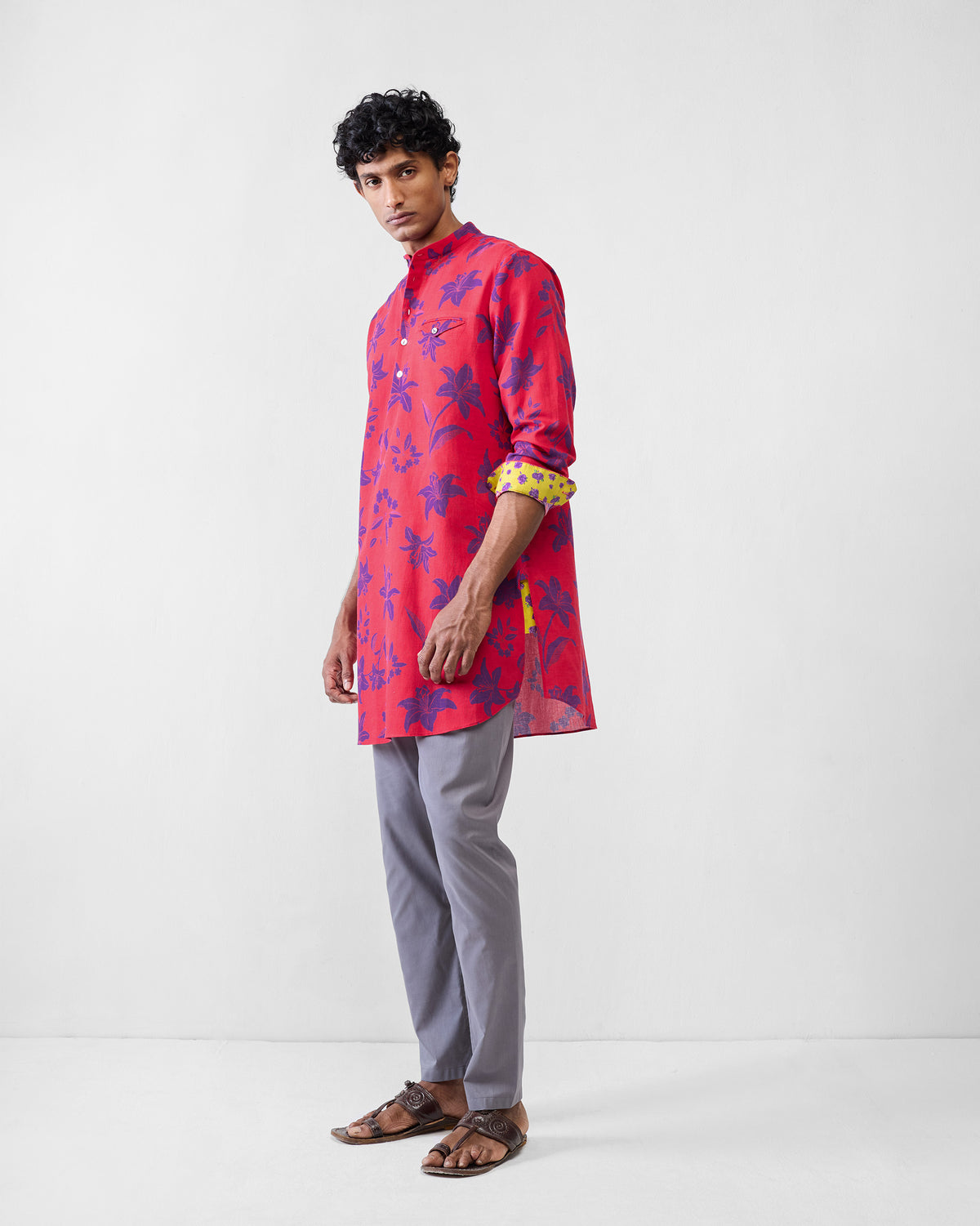 Person wearing a red Fort kurta with yellow floral contrast cuff lining.