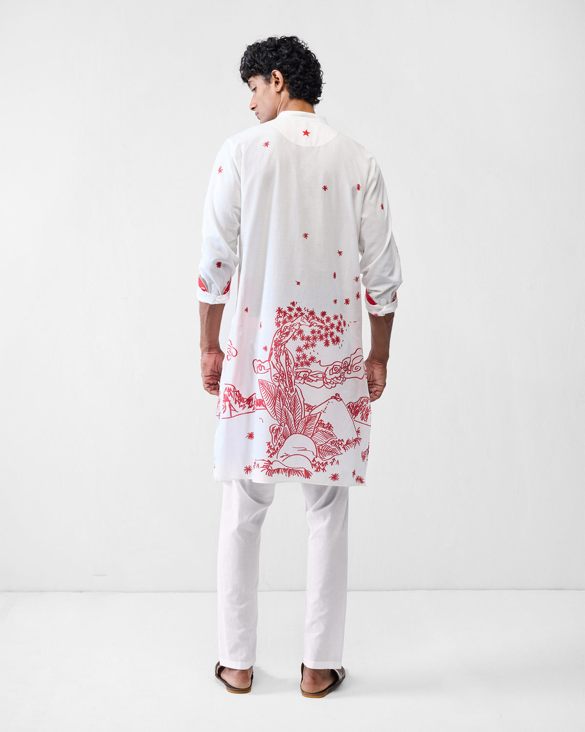 Back of a white Neckband Kurta with a red landscape print and a red embroidered star.