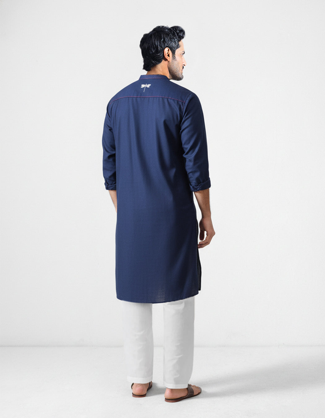 Back of a navy Talha kurta with a white dragonfly embroidery.