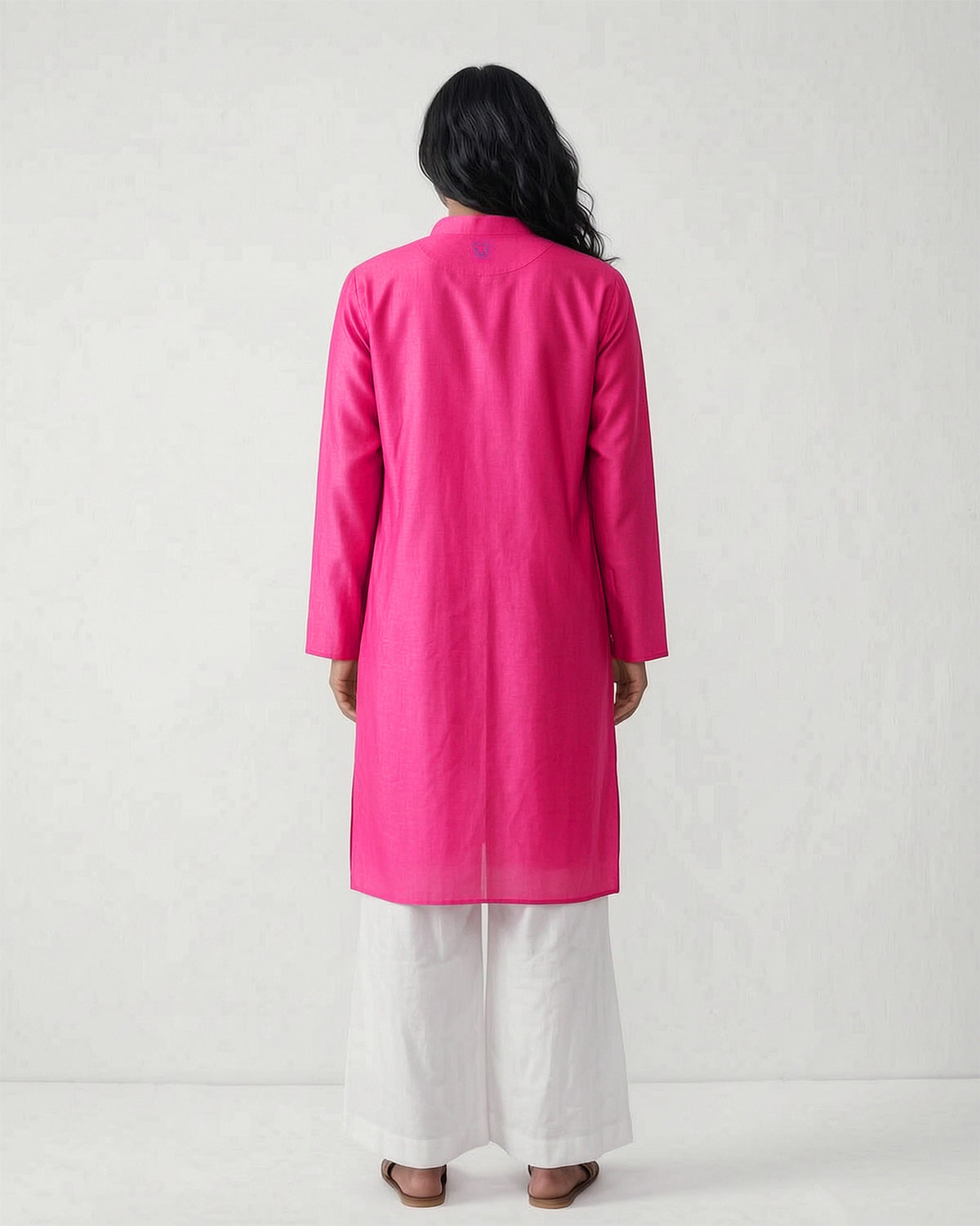 Back of a fuchsia Long pleated kurta with long sleeves worn by a person.