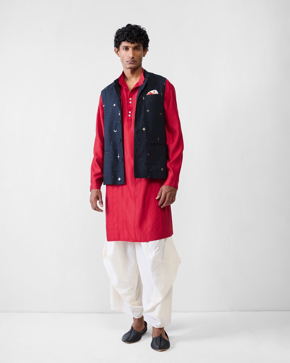 Person wearing a red Long Pleated Kurta under a navy embroidered waistcoat.