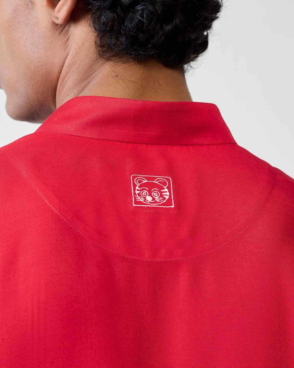 Close-up of a red Long Pleated Kurta back with a white embroidered dog face.