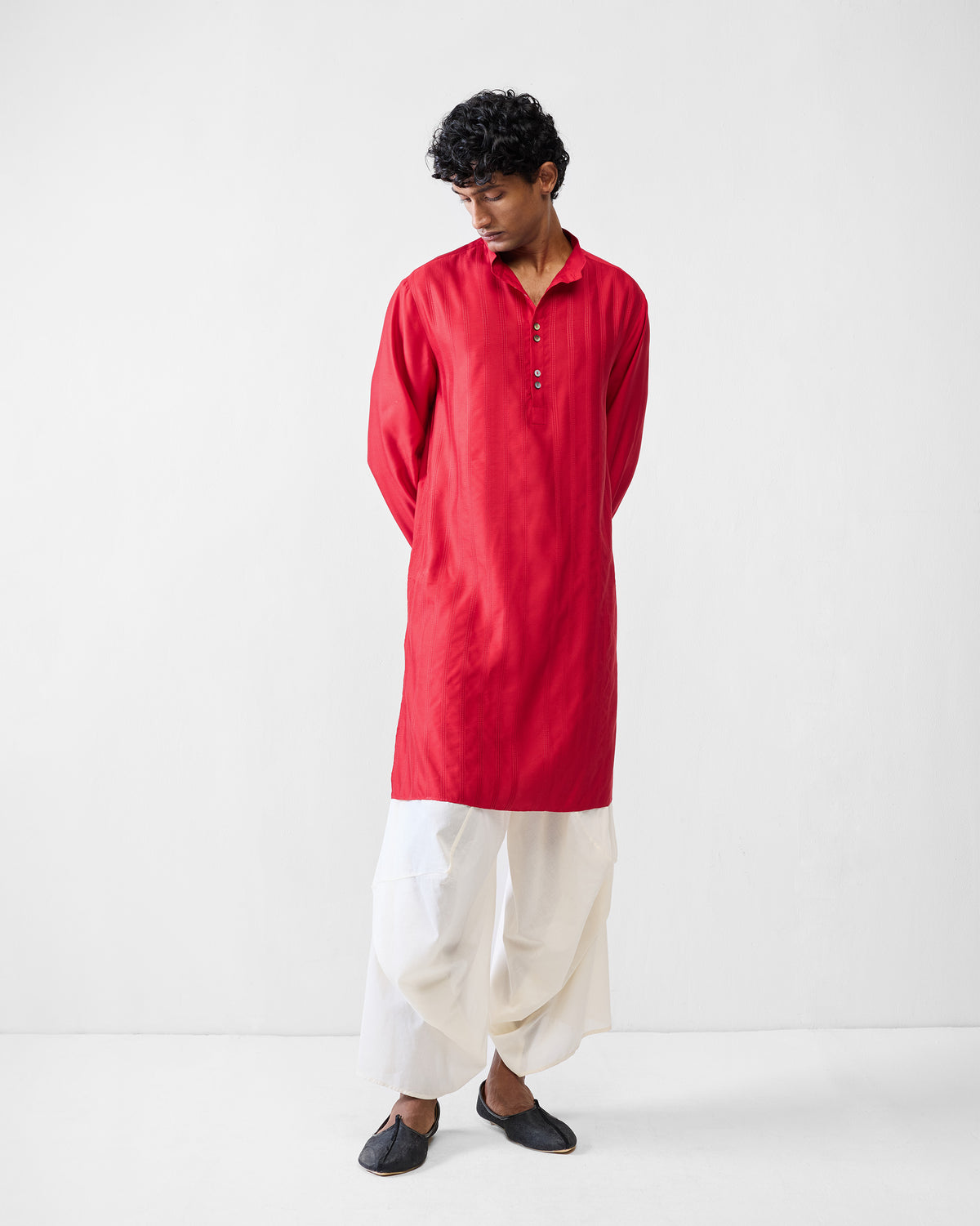 Person wearing a vivid red Long Pleated Kurta with a short button placket.