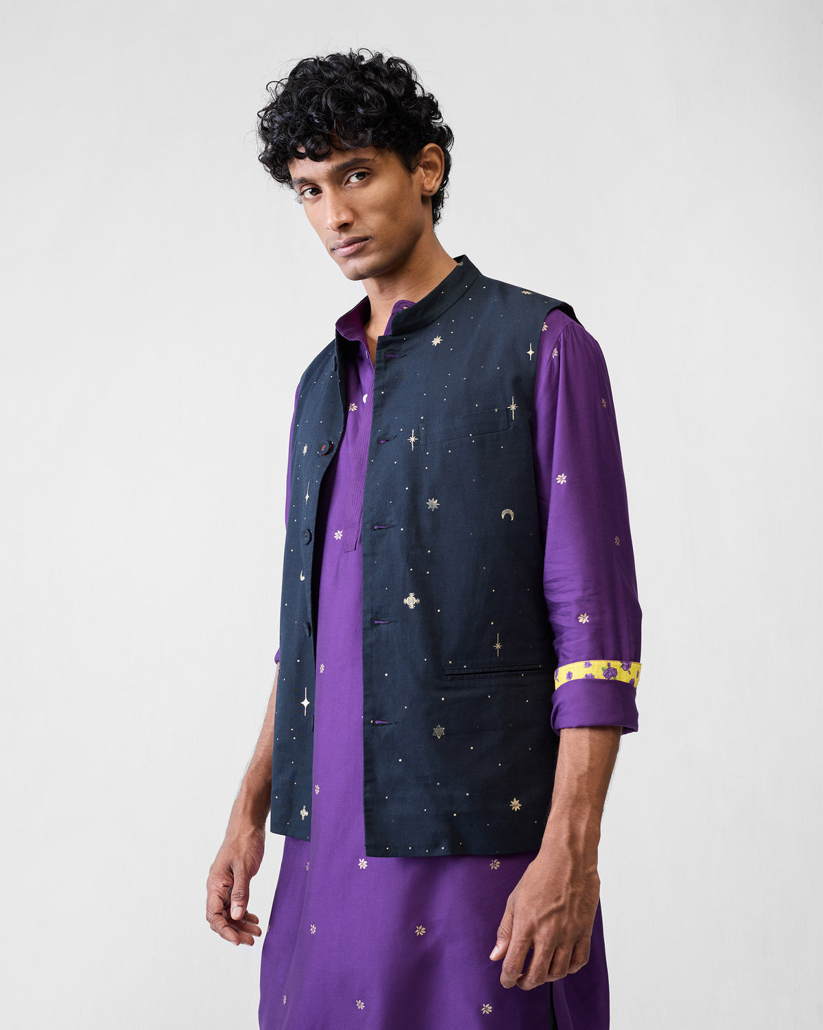 Person wearing a purple Neckband Kurta under a navy embroidered waistcoat.