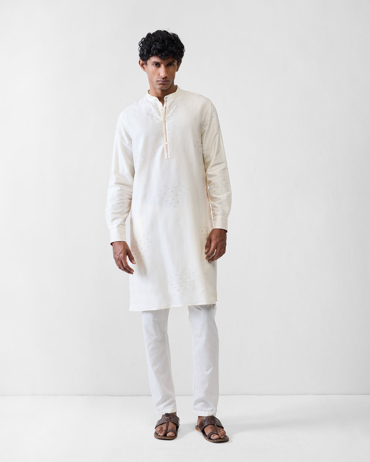 Person wearing an ivory astral kurta with silver heart embroidery.
