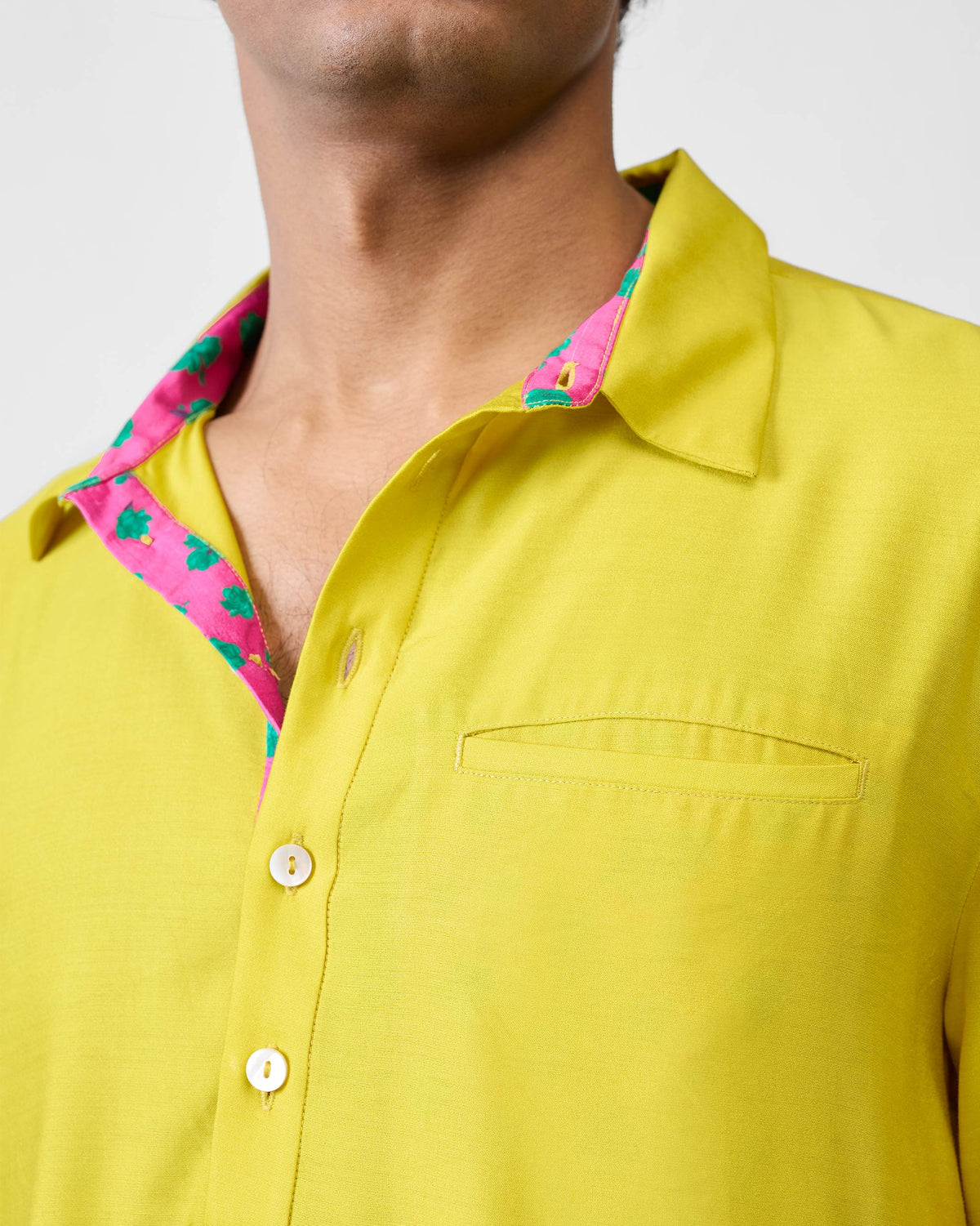 Close-up of a chartreuse Bouquet kurta showing pink collar lining.