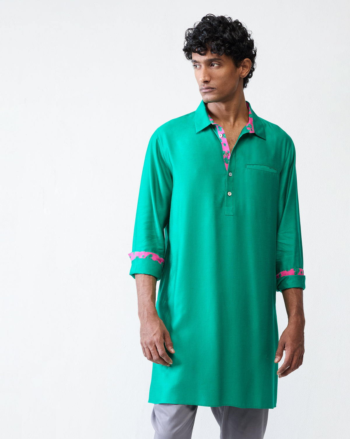 Person wearing an emerald green Bouquet kurta with pink floral cuff lining.