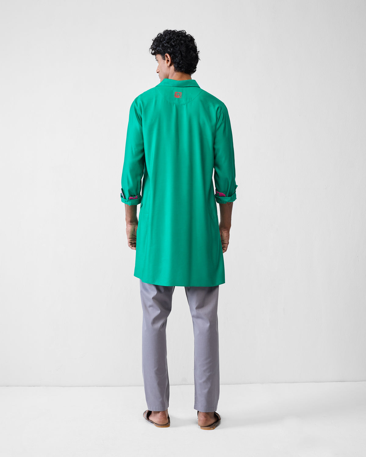 Back of an emerald green Bouquet kurta with a red embroidered motif.