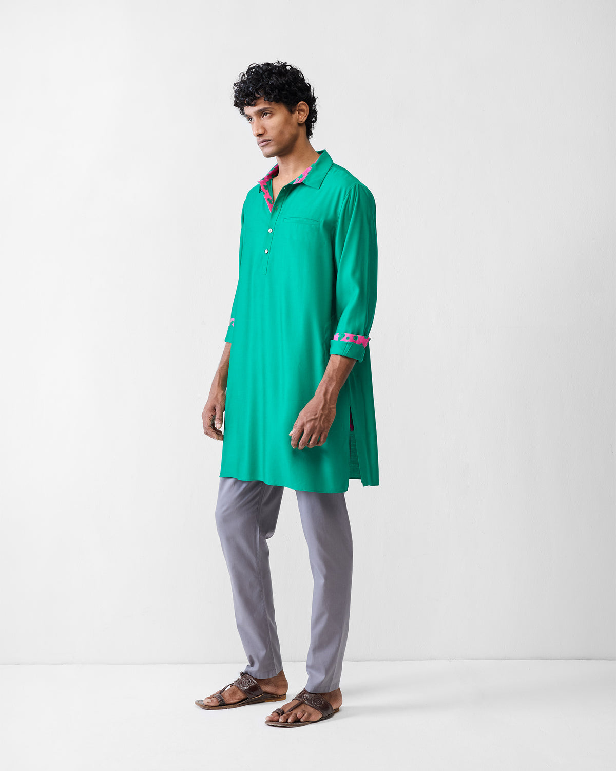 Side view of an emerald green Bouquet kurta with pink cuff lining.