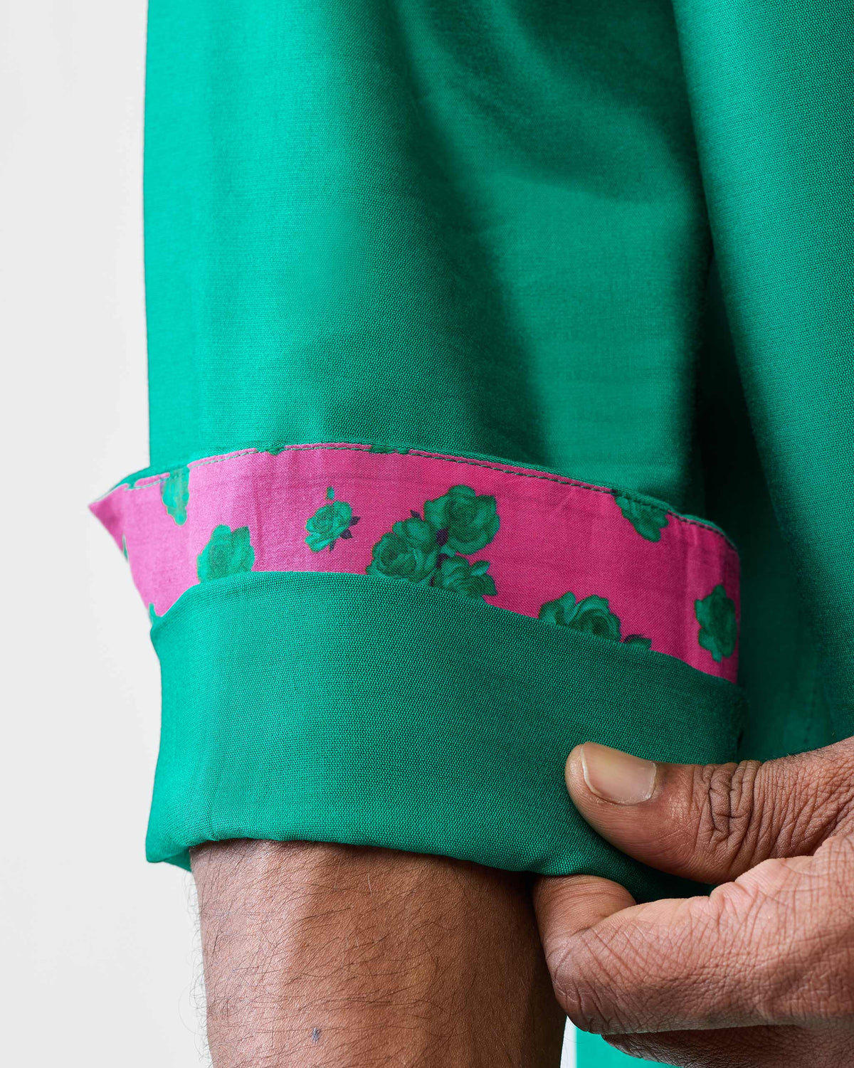 Close-up of pink floral cuff lining on an emerald green Bouquet kurta.