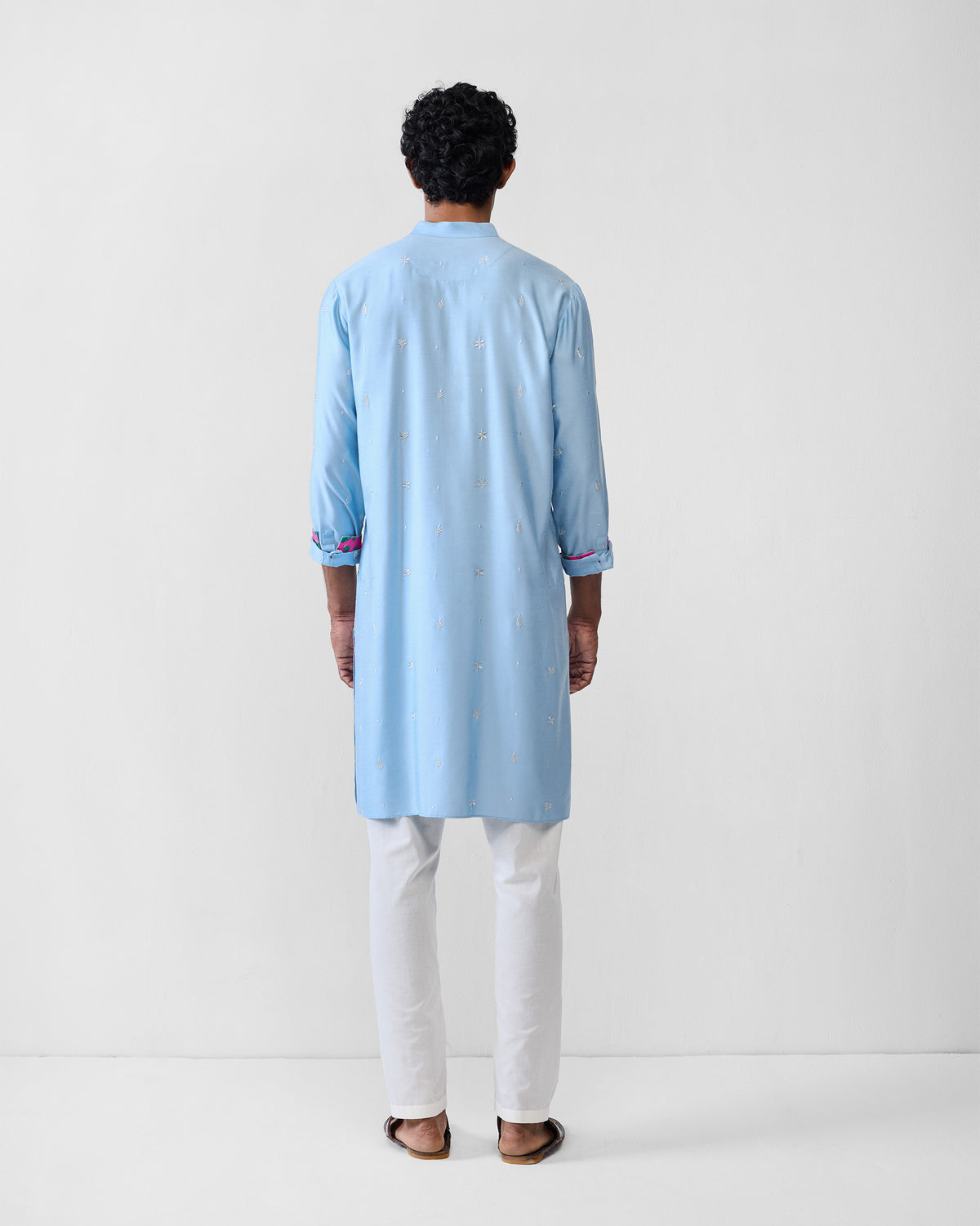 Back of a light blue embroidered Rey kurta worn by a person.