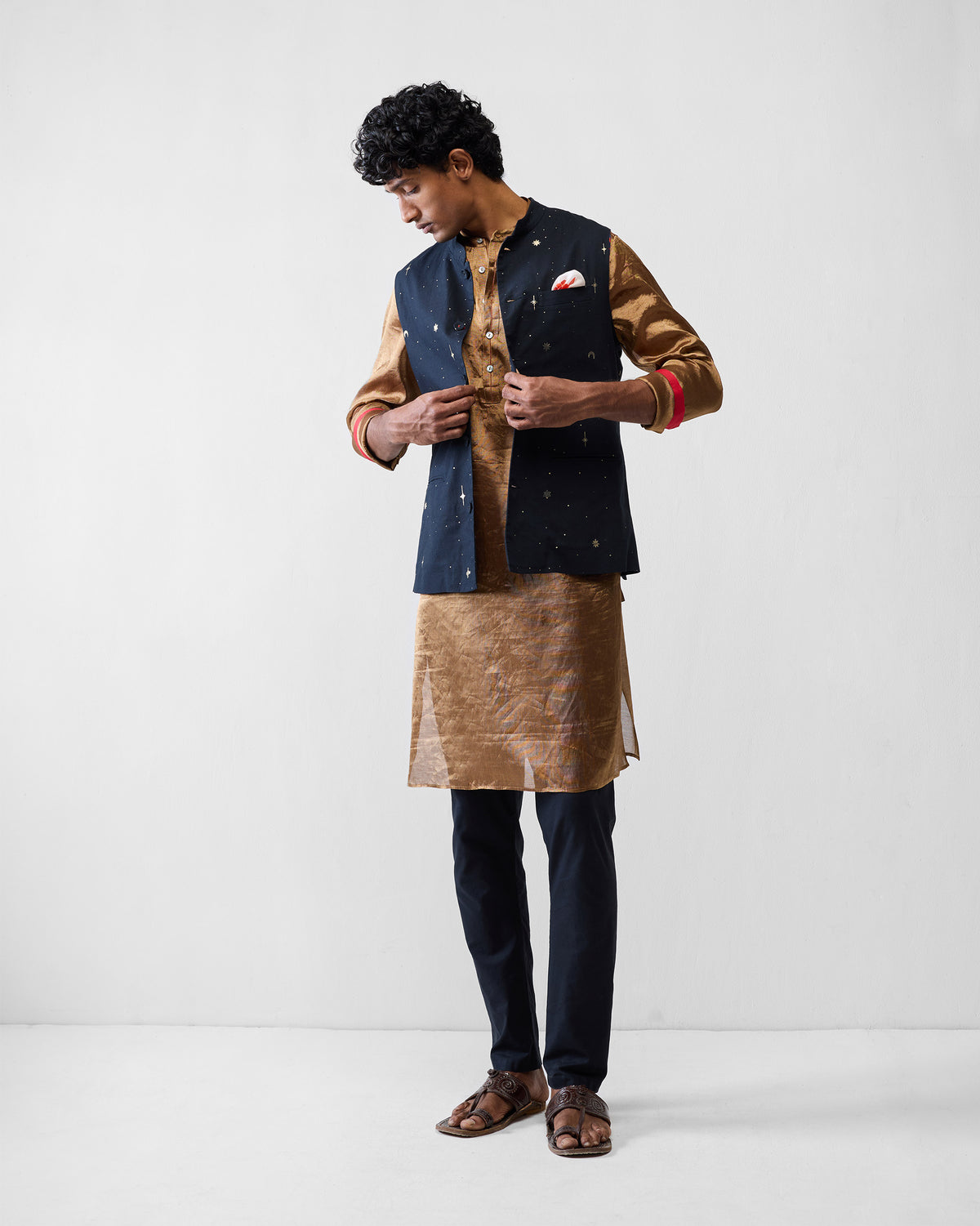 Person wearing a gold Chandni Chowk kurta under a navy jacket.