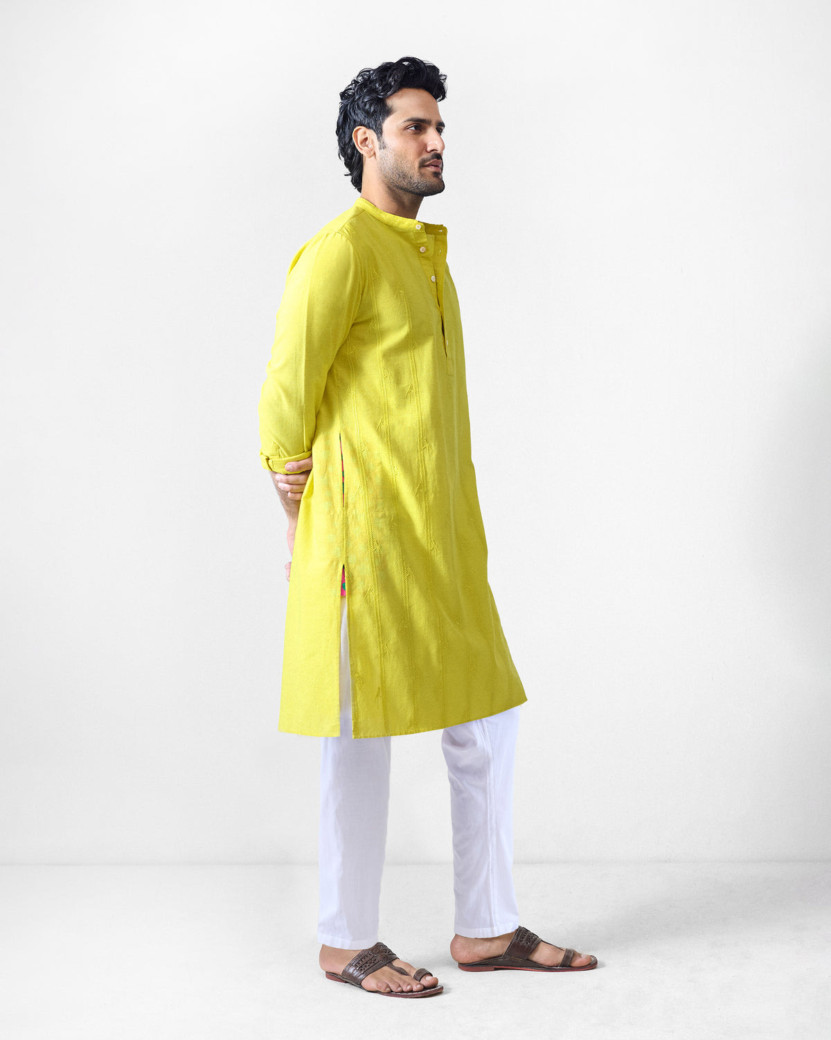 Side view of a chartreuse Ibn Kurta showing the knee length and side slit.