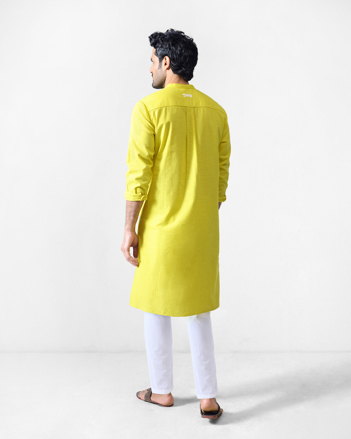 Back of a chartreuse Ibn Kurta with a center pleat and white neck embroidery.