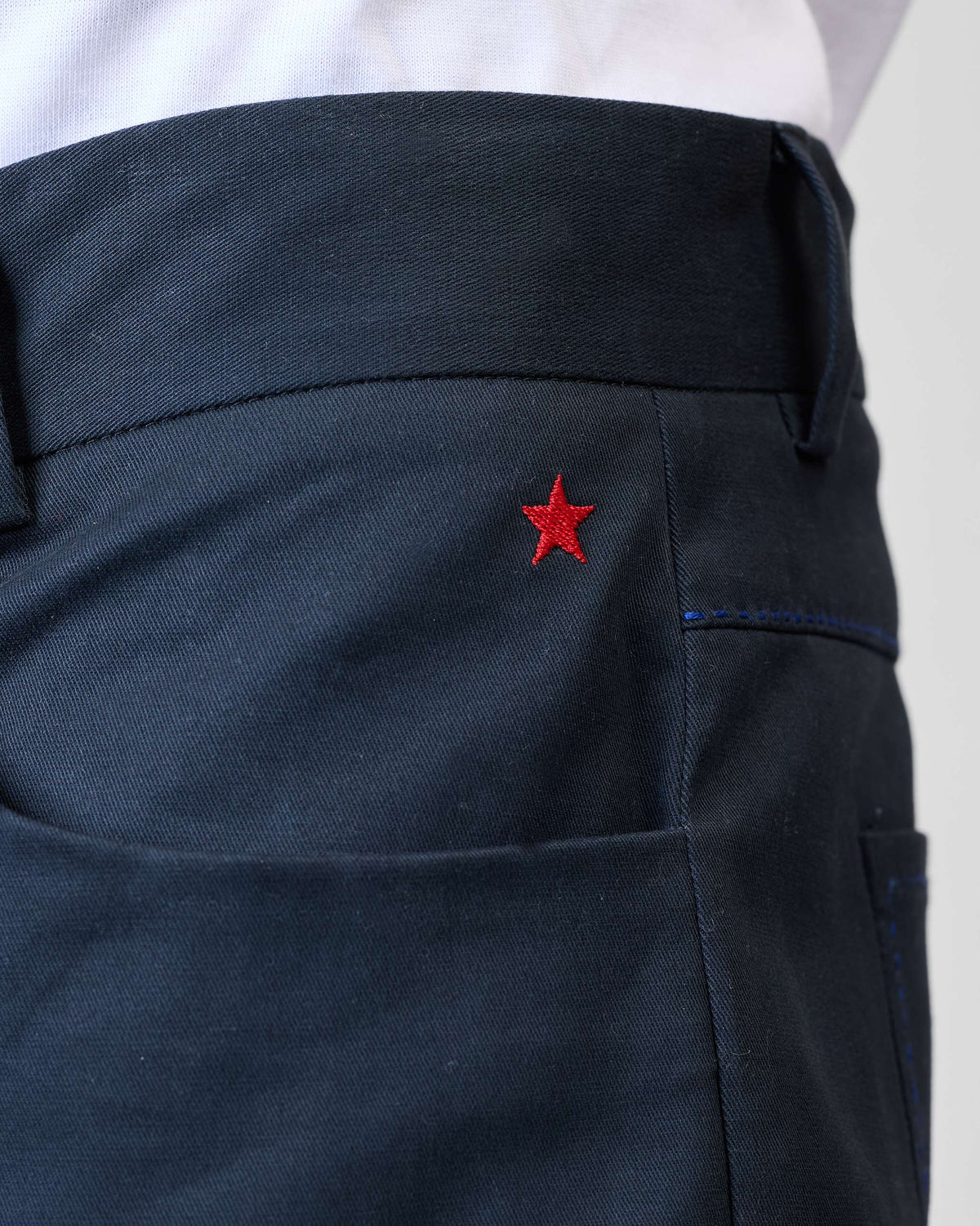 Close-up of black Viraas pants with a small red star near the pocket.