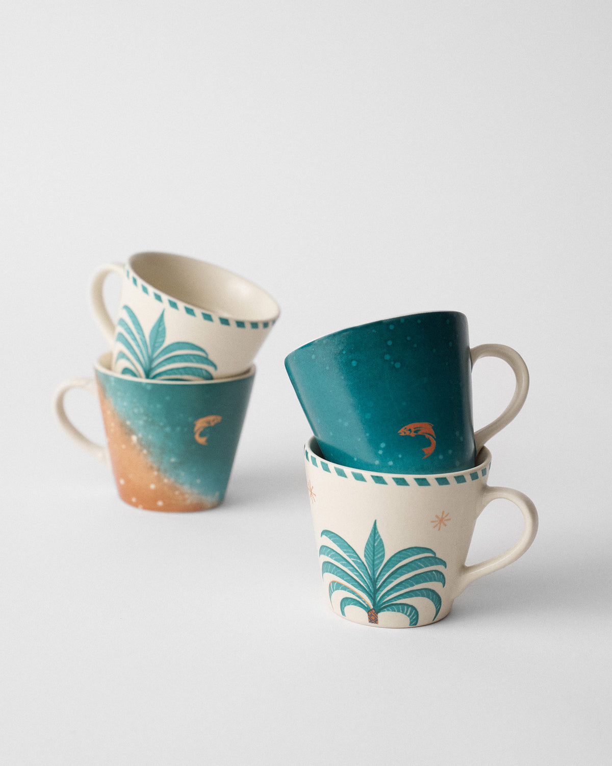 Stacked Aluna Espresso Mugs showing palm-tree and teal seascape designs.