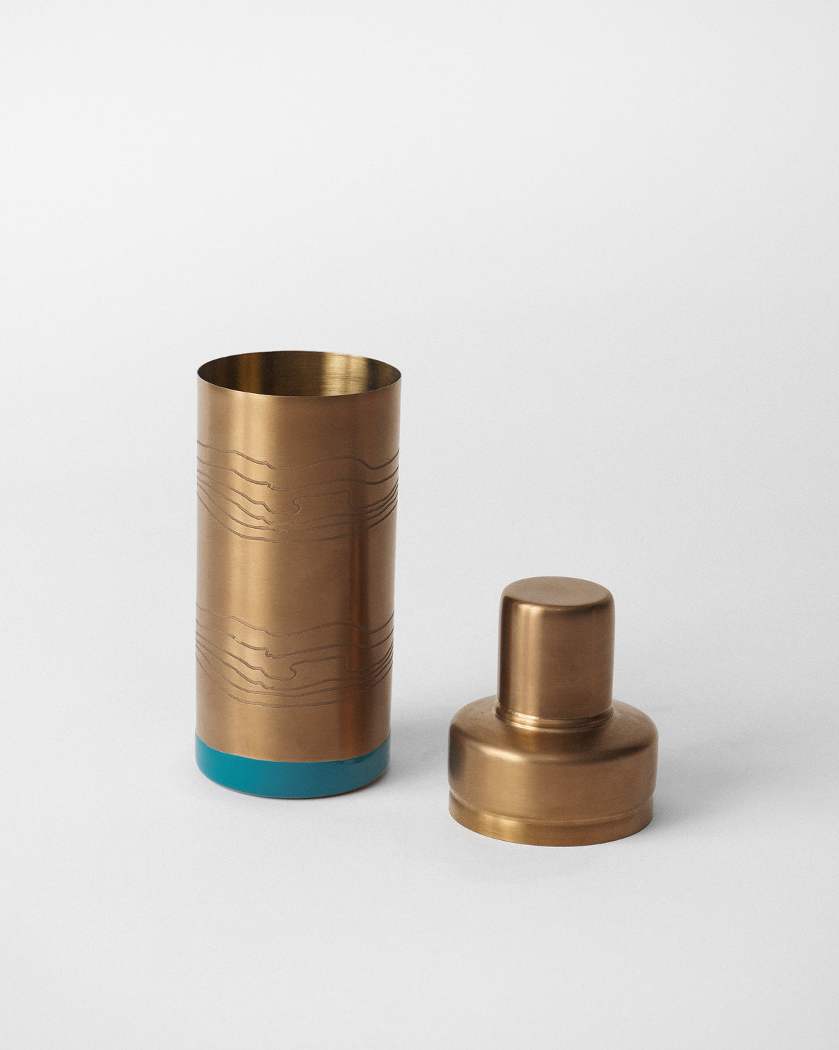 Open Caden cocktail shaker showing the brass body and stepped lid.