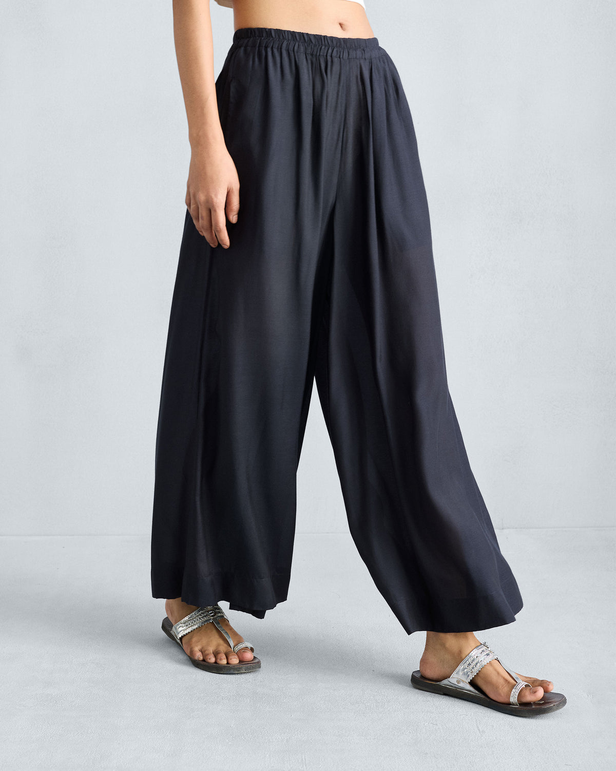 Person wearing black Classic Pyjama pants showing a fluid wide-leg drape.