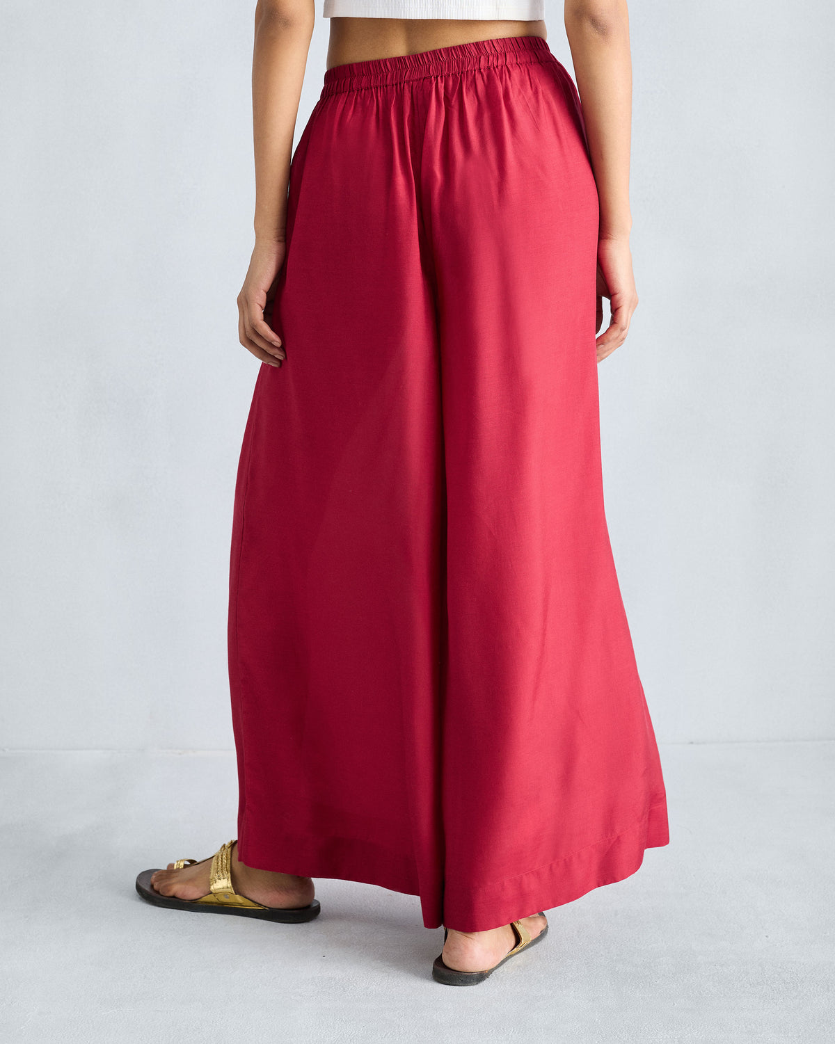 Back of red Classic Pyjama pants with a gathered waist and flowing wide legs.