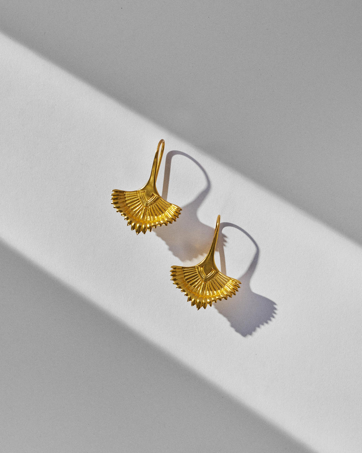 Pair of gold Festive Palm danglers with ridged fan shapes and curved hooks.