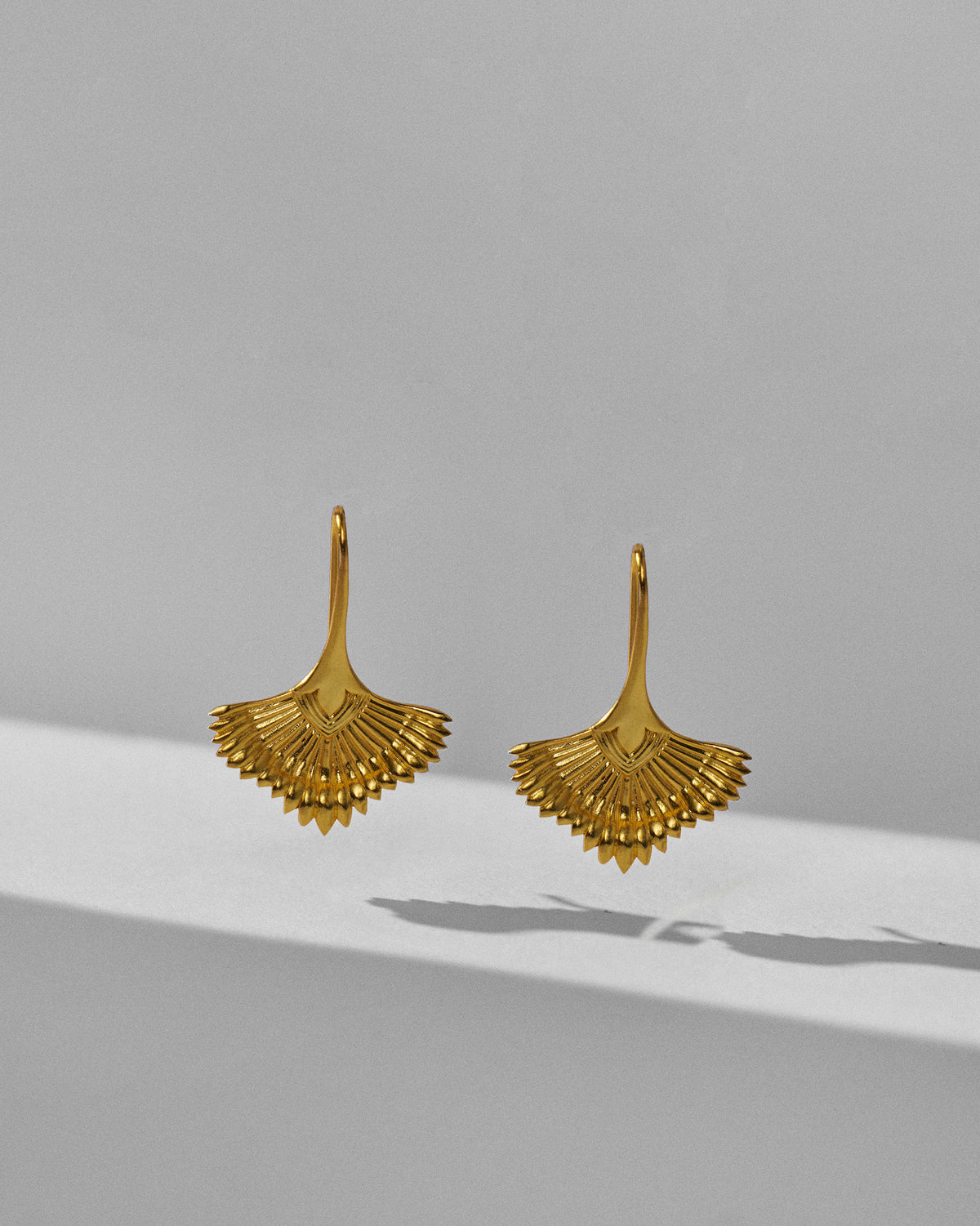 Pair of gold Festive Palm danglers with pointed ridged rays.