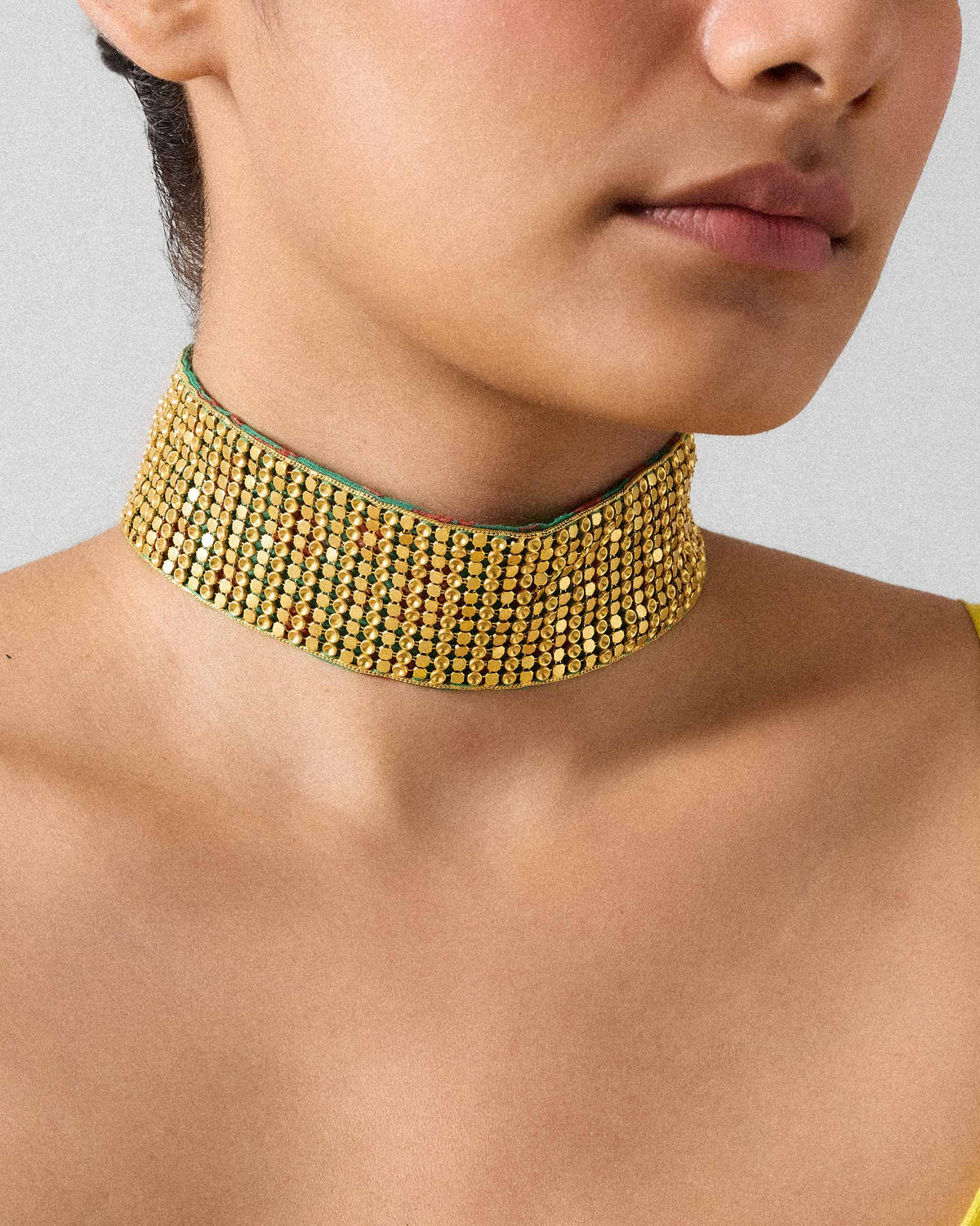 Wide gold Chain Mail choker of disc mesh with a green fabric edge.