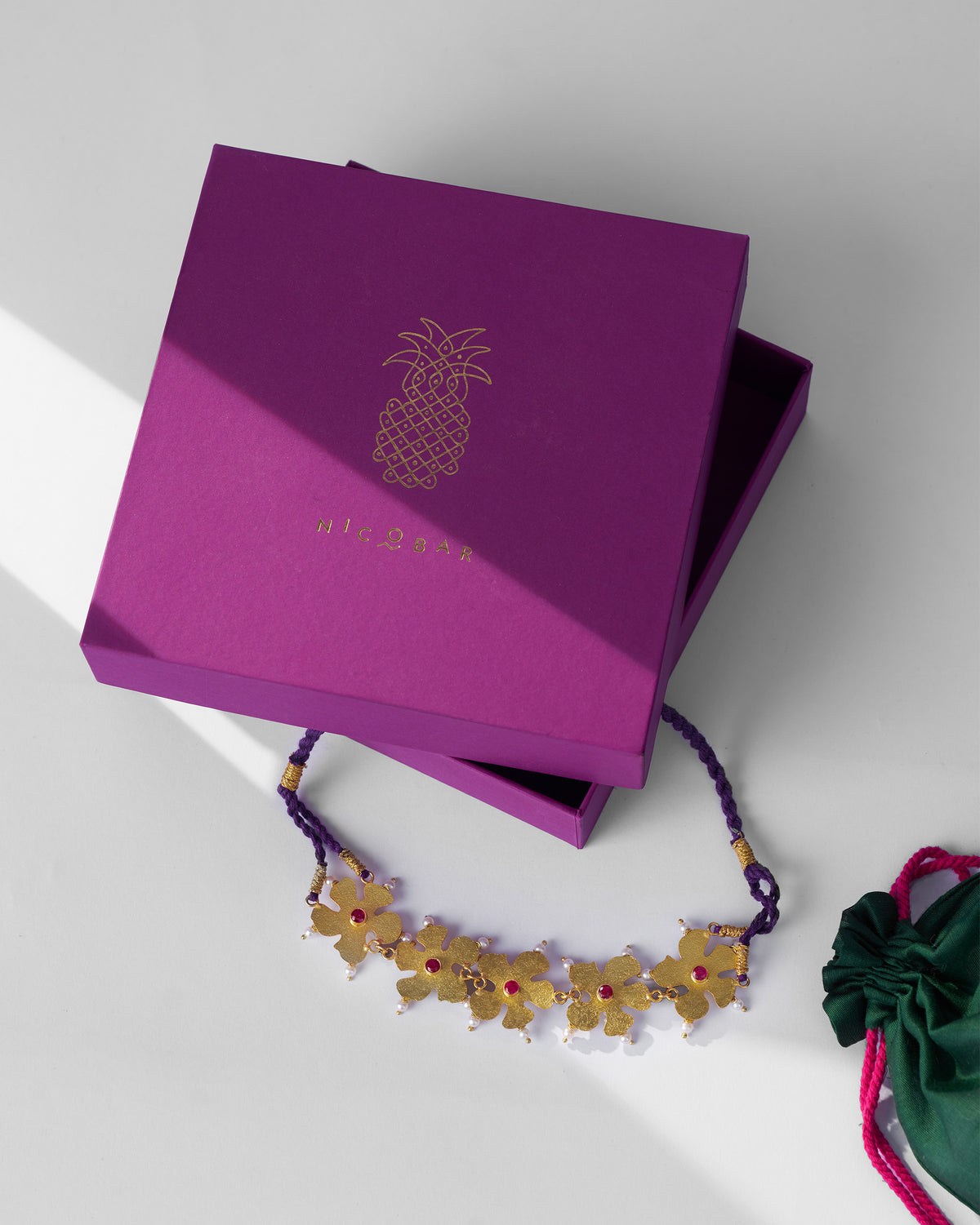 Gold phool haar necklace beside a Nicobar jewellery box.