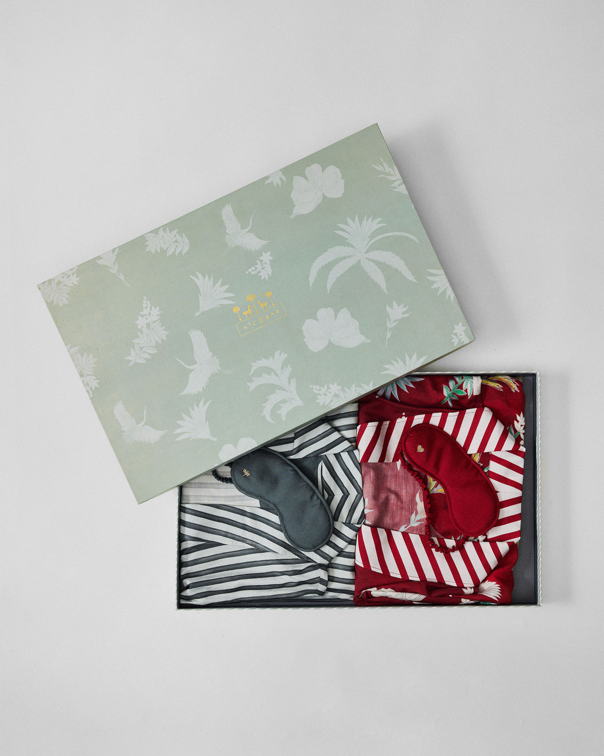 Partly open Reverie gift box revealing folded robes and eye masks.