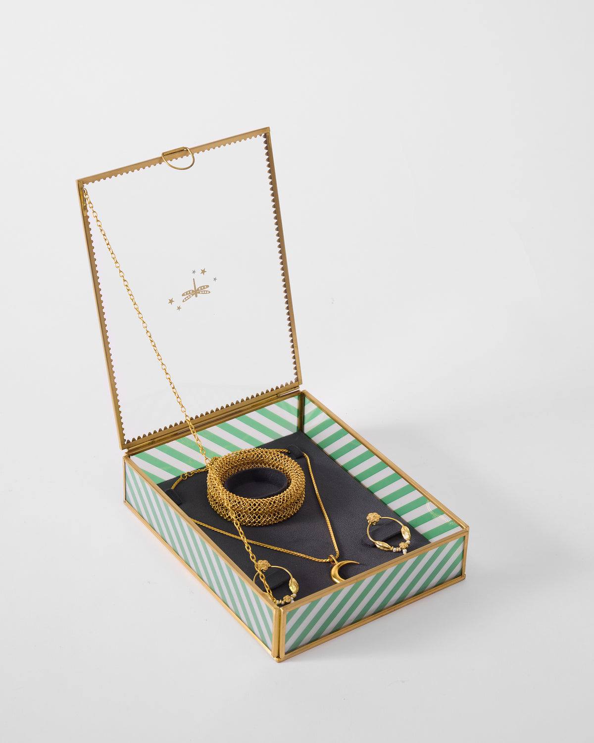 Open Trove jewellery box holding gold jewellery on a dark lining.