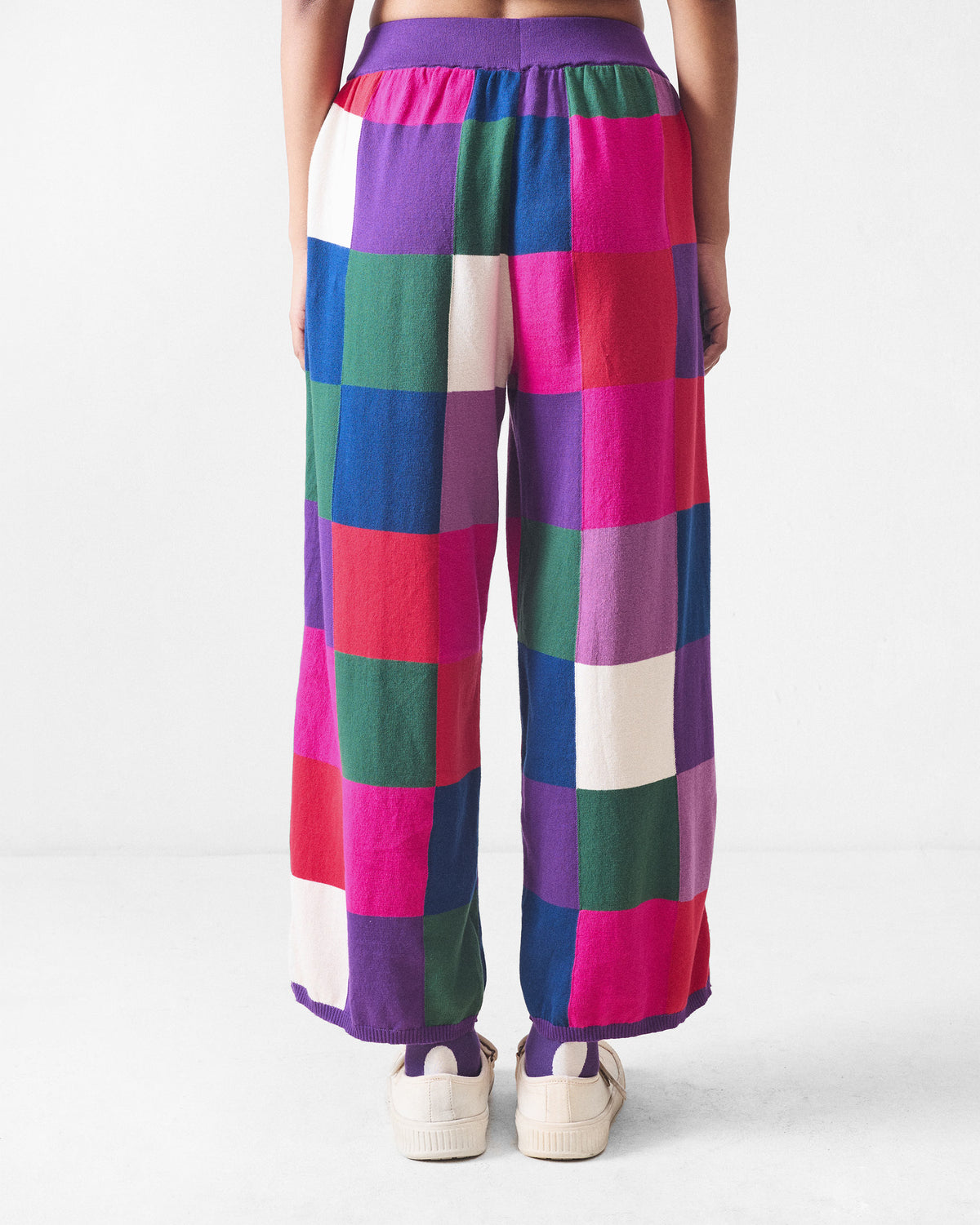 Back of multicolour check knit trousers with a purple ribbed waistband.