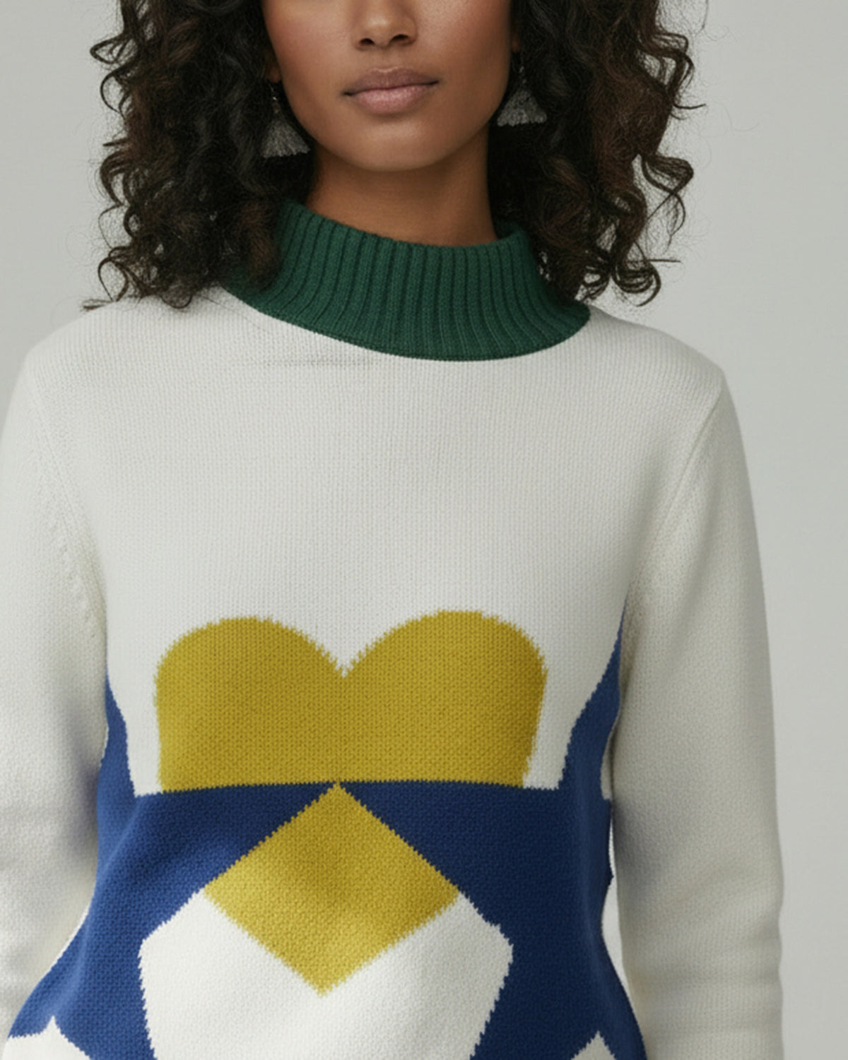 Close-up of an ivory Crew Neck Sweater showing a yellow heart and navy star.