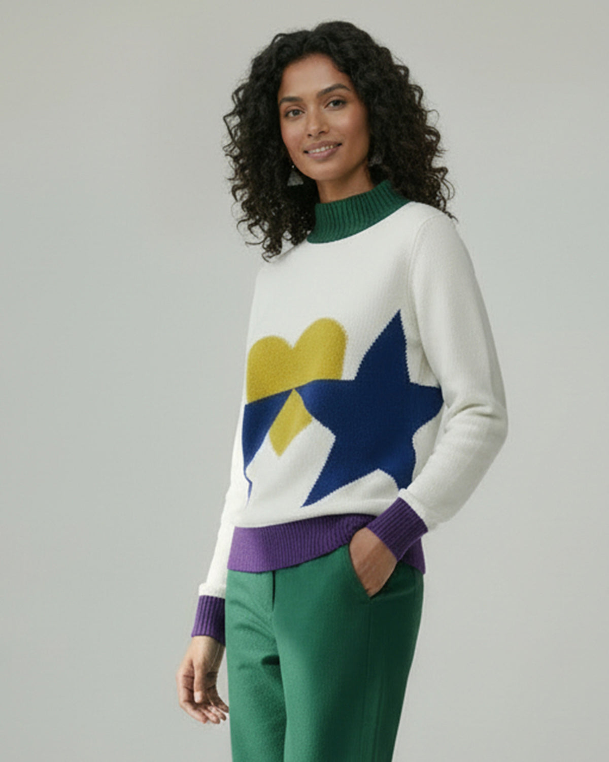 Person wearing an ivory Crew Neck Sweater with green collar and purple cuffs.