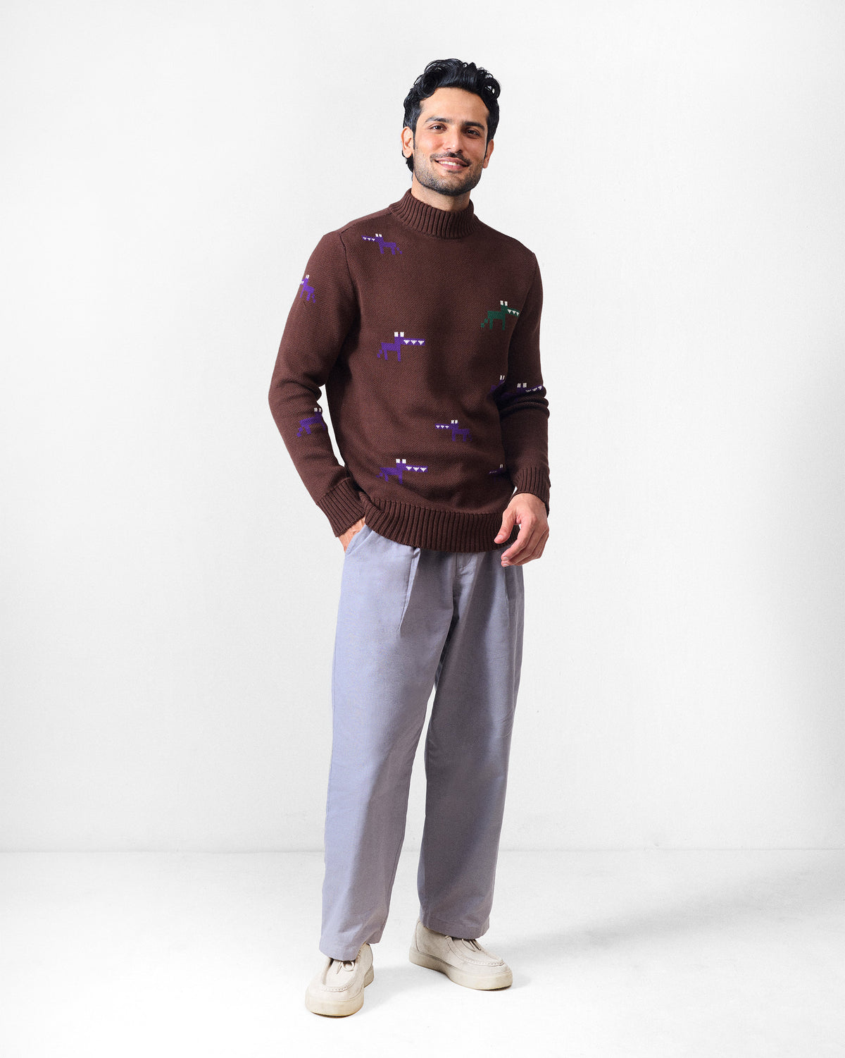 Full view of a brown crew neck sweater with colourful pixel motifs.