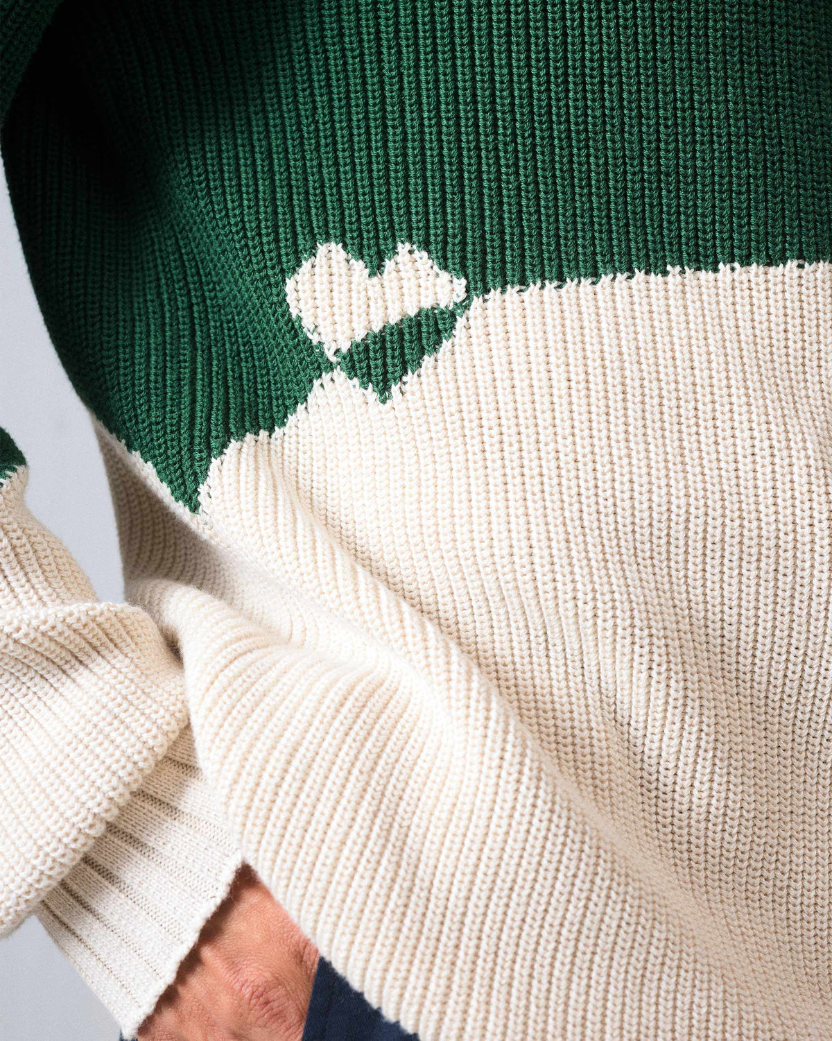 Close-up of a cream heart motif on a green and ivory colour-block sweater.