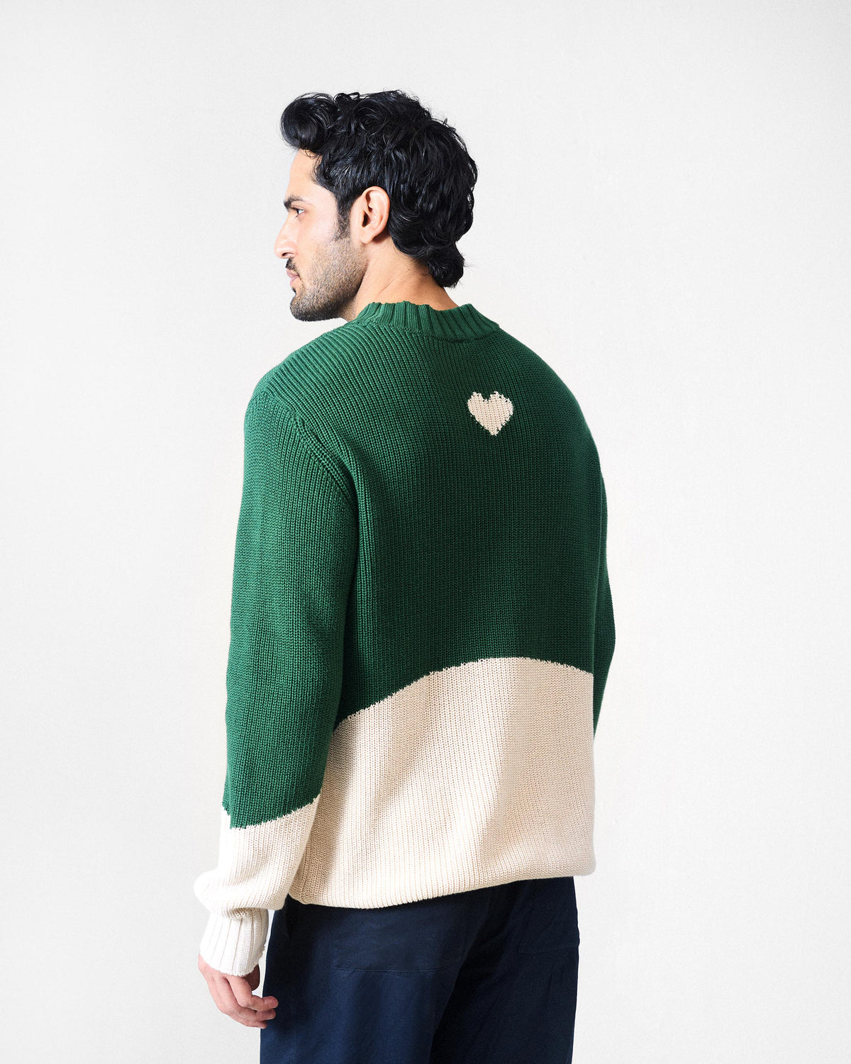 Back of a green and ivory crew neck sweater with a cream heart motif.