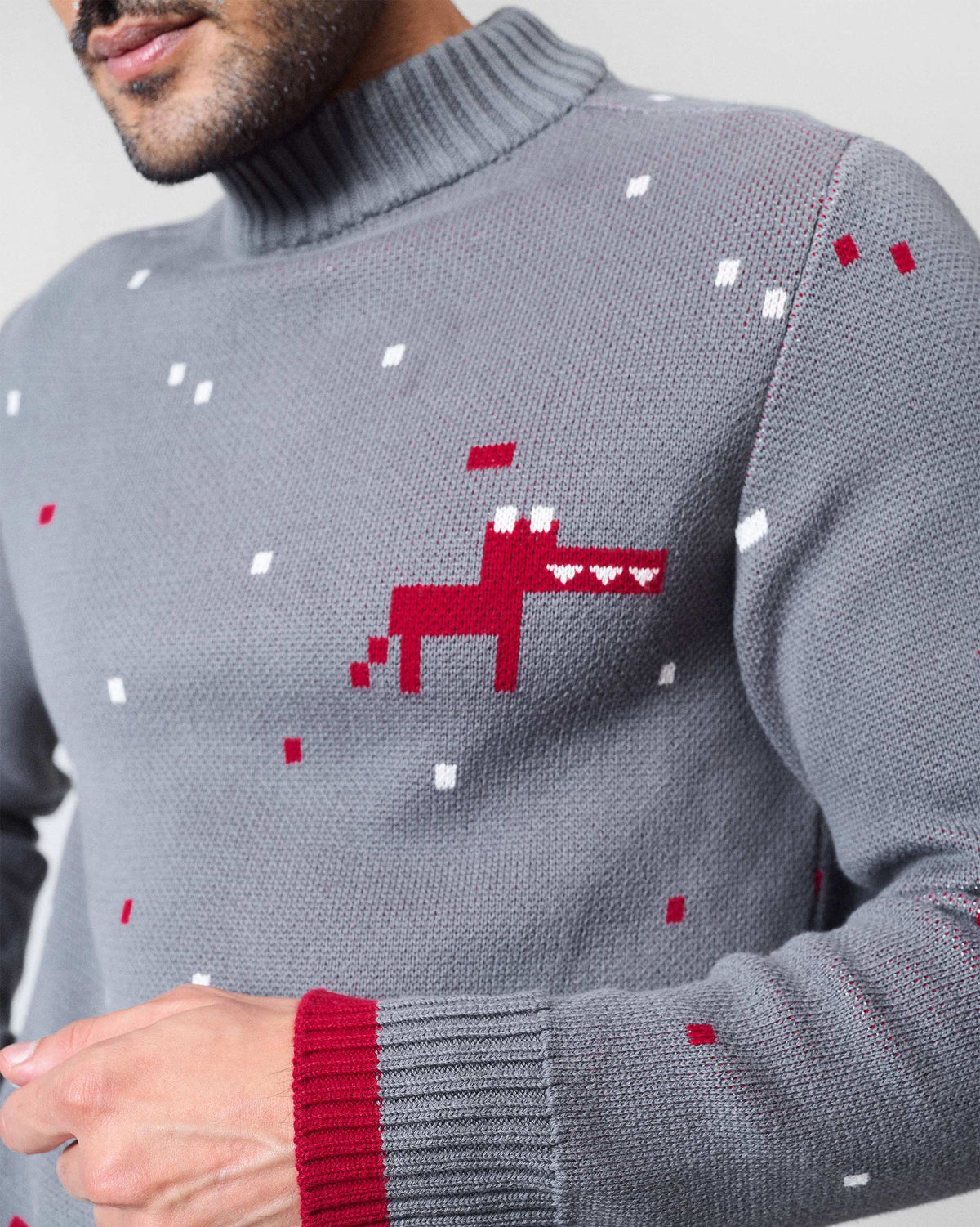 Close-up of a charcoal Crew Neck sweater showing a red pixel dino and ribbed mock neck.
