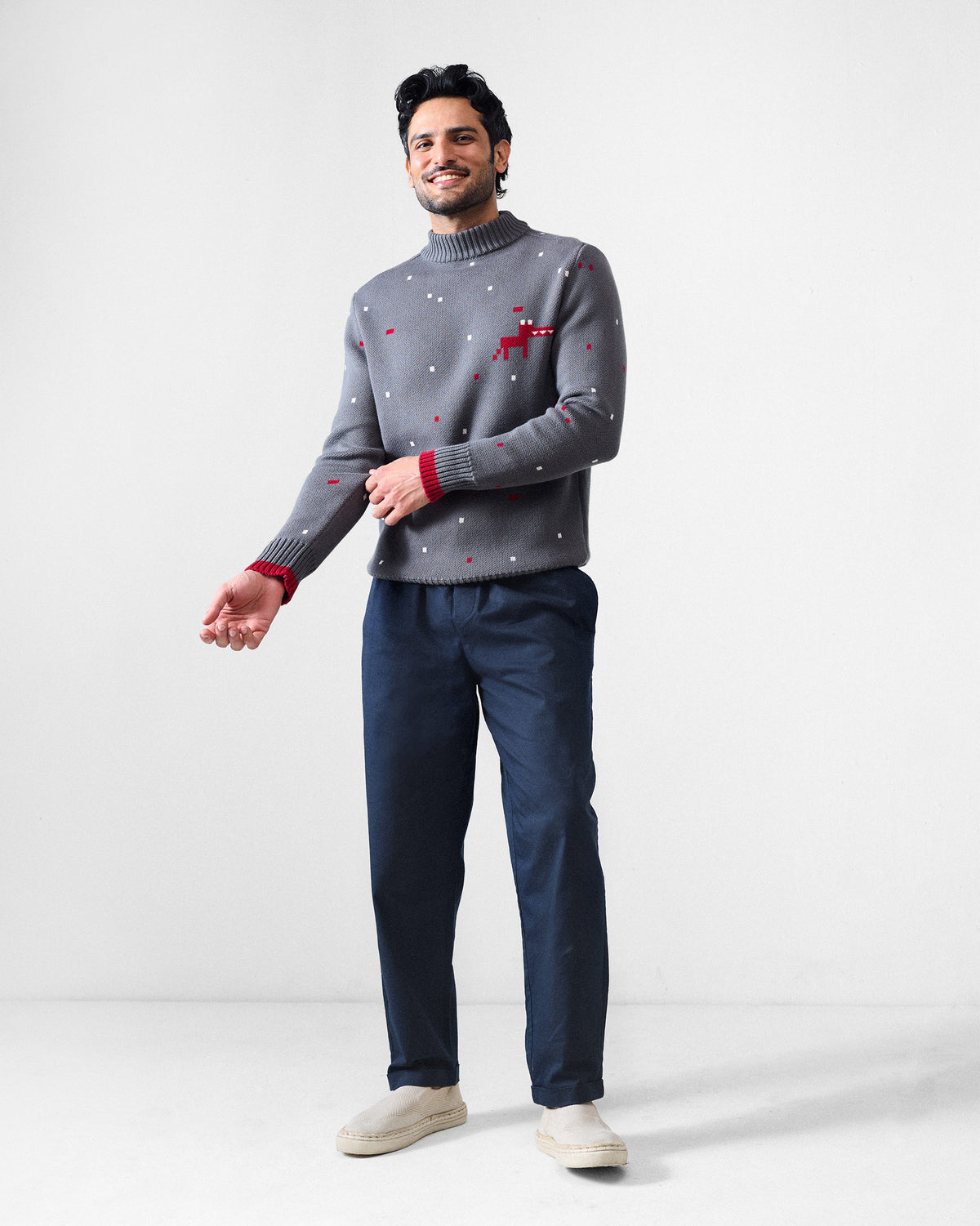 Person wearing a charcoal Crew Neck sweater with a pixel pattern and red cuff tipping.
