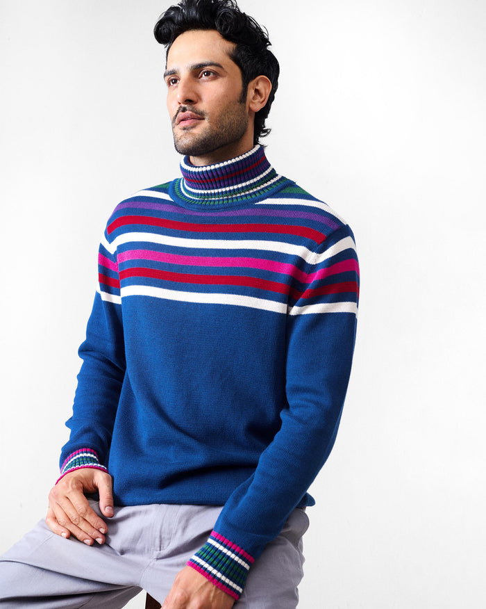 Person wearing a navy Ringer sweater with multicolour stripes across the chest.