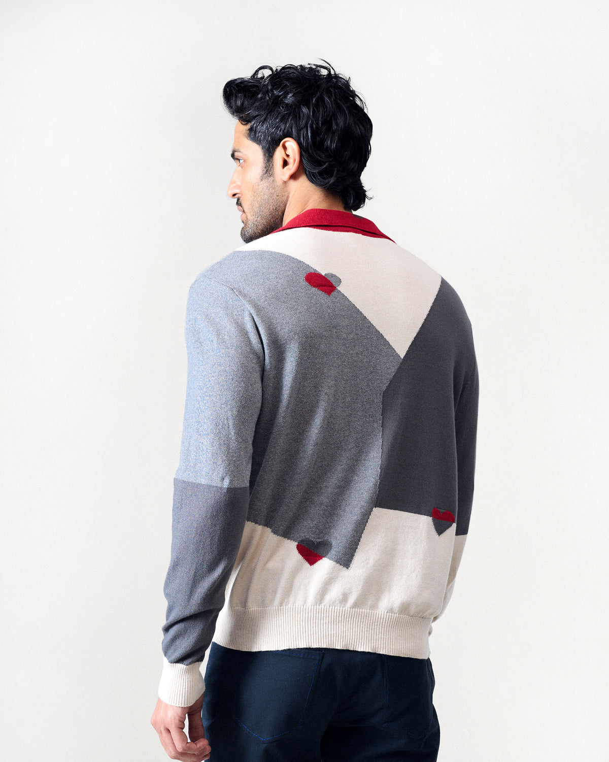 Back of a grey Dom Sweater with cream blocks and red heart motifs.