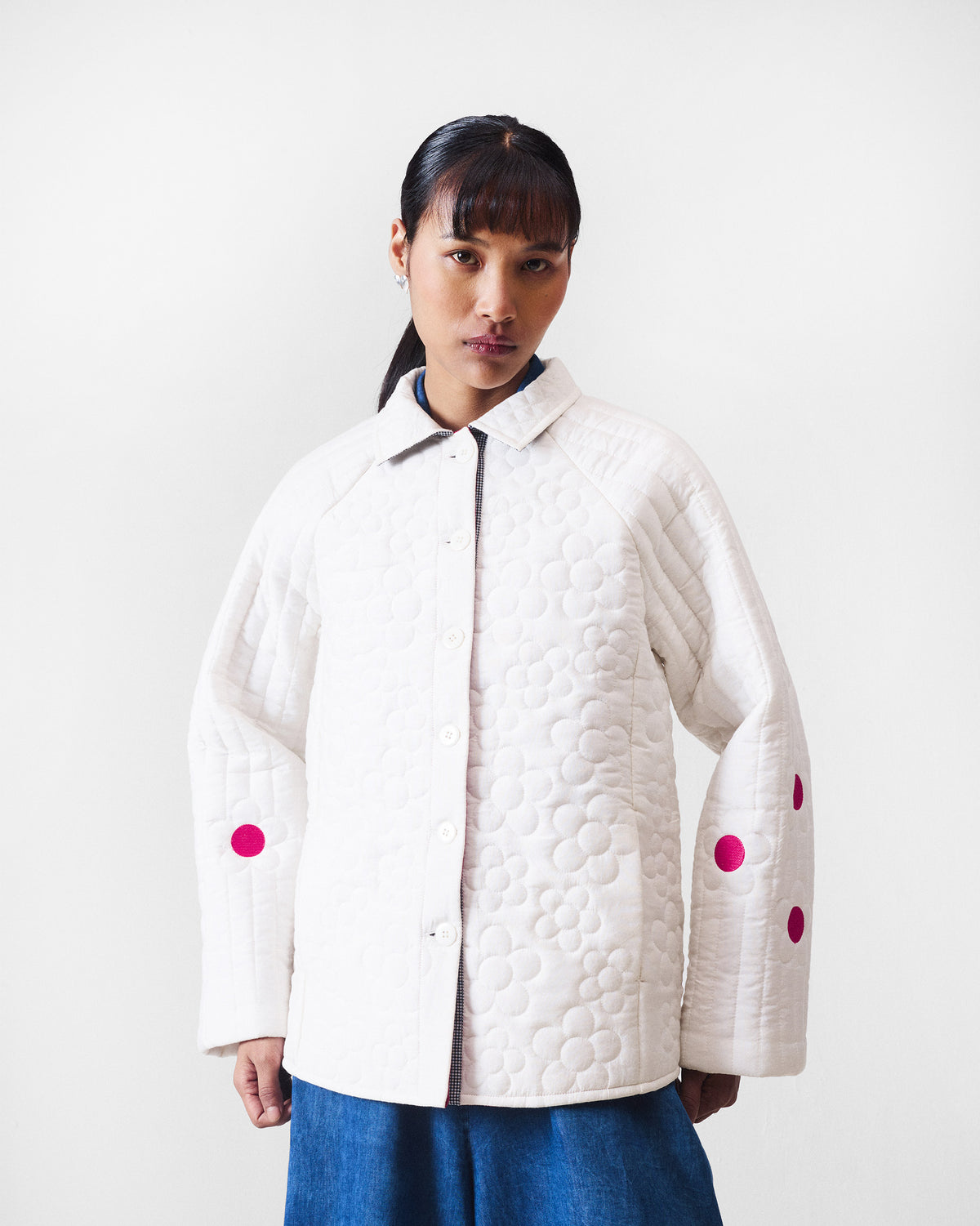 Ivory quilted Botanik jacket with a pointed collar and fuchsia accents on the sleeves.