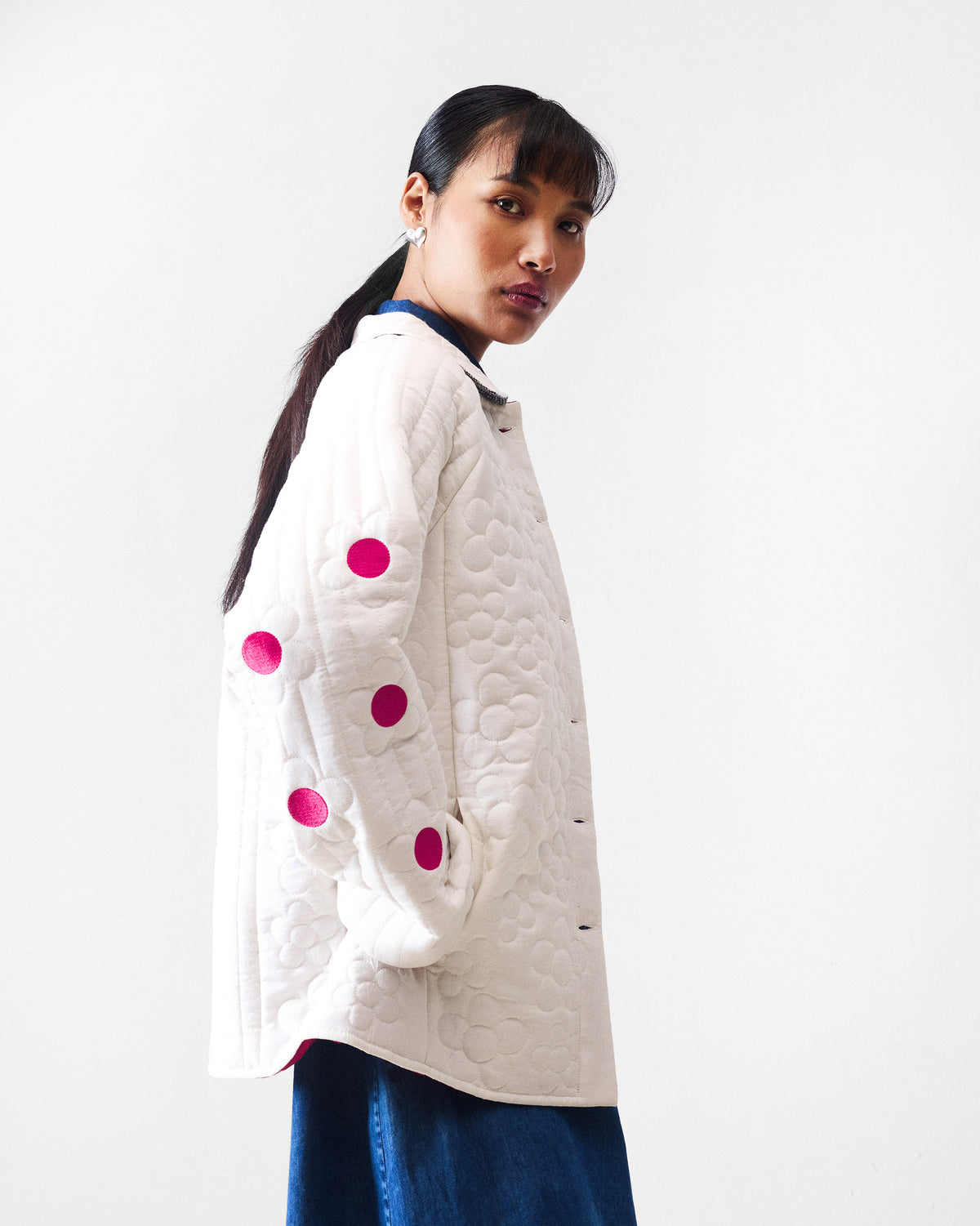 Side view of an ivory Botanik jacket highlighting fuchsia flower centres down the sleeve.