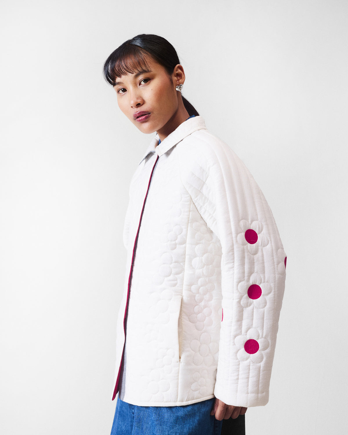 Side view of an ivory Botanik jacket with fuchsia flower centres along the sleeve.