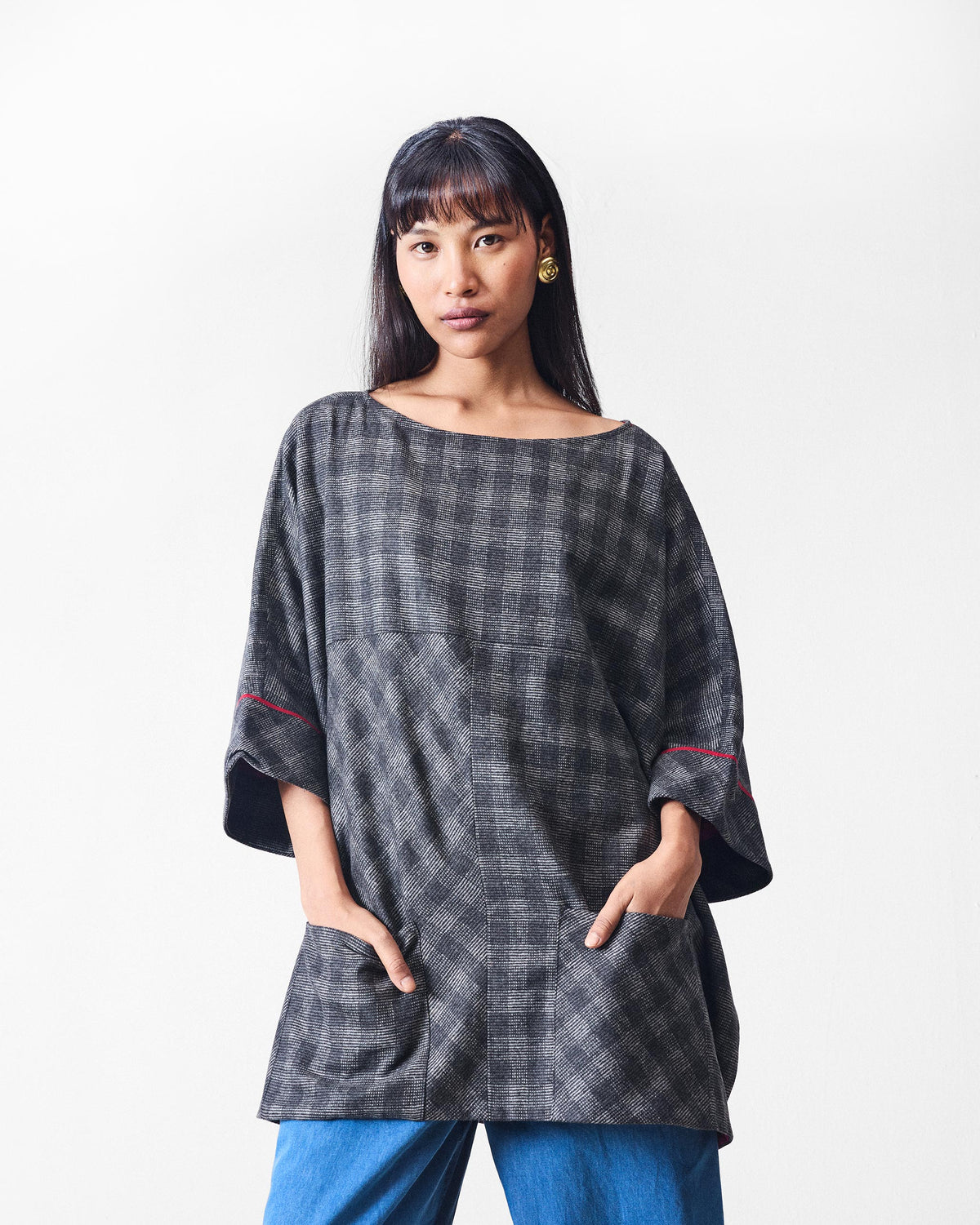 Fable Top front in black and charcoal check with red sleeve accents.