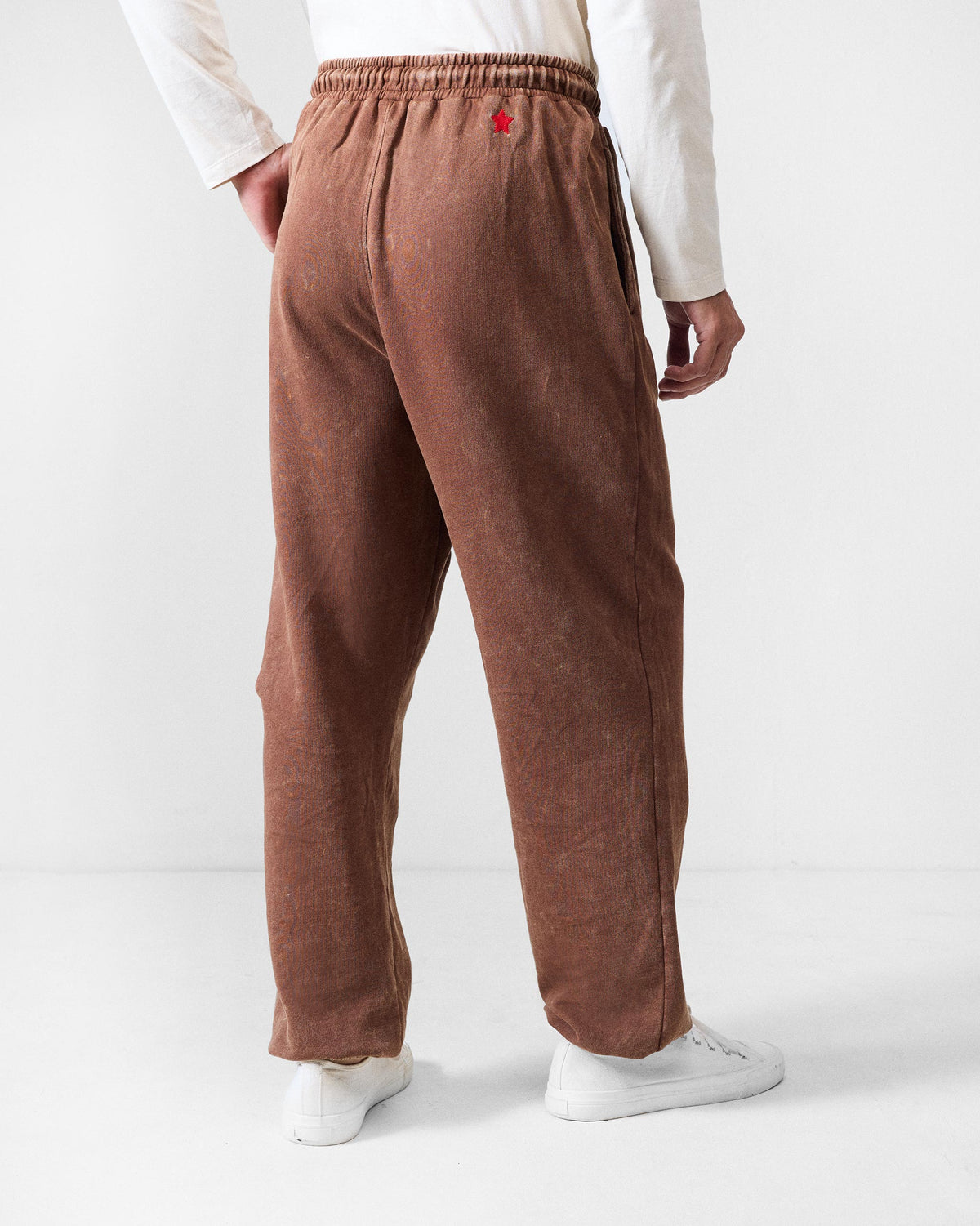 Back of brown Drift bottoms with a red star embroidery above the pocket.